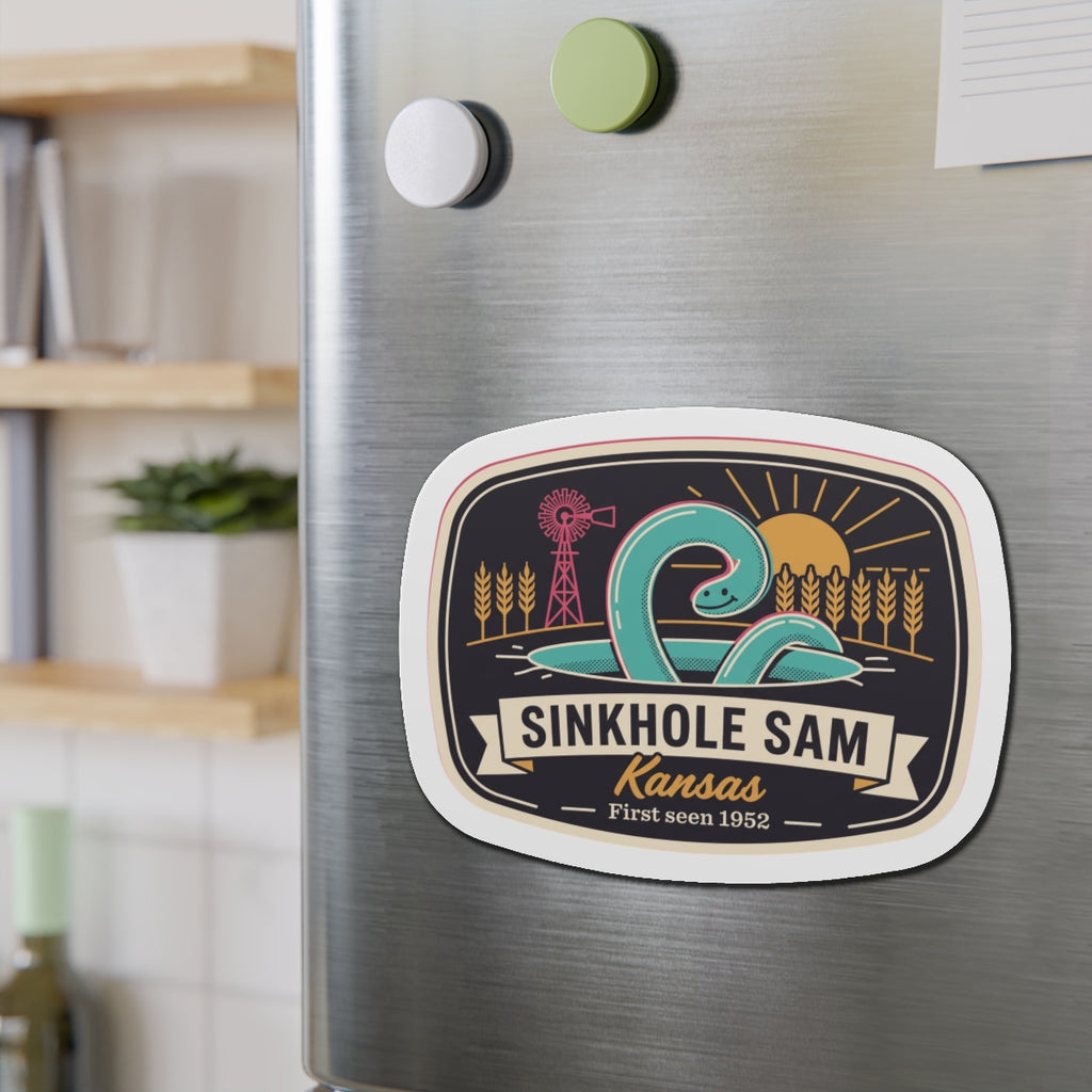 Oval die-cut sticker-style magnet with Sinkhole Sam Kansas graphic on brushed stainless steel