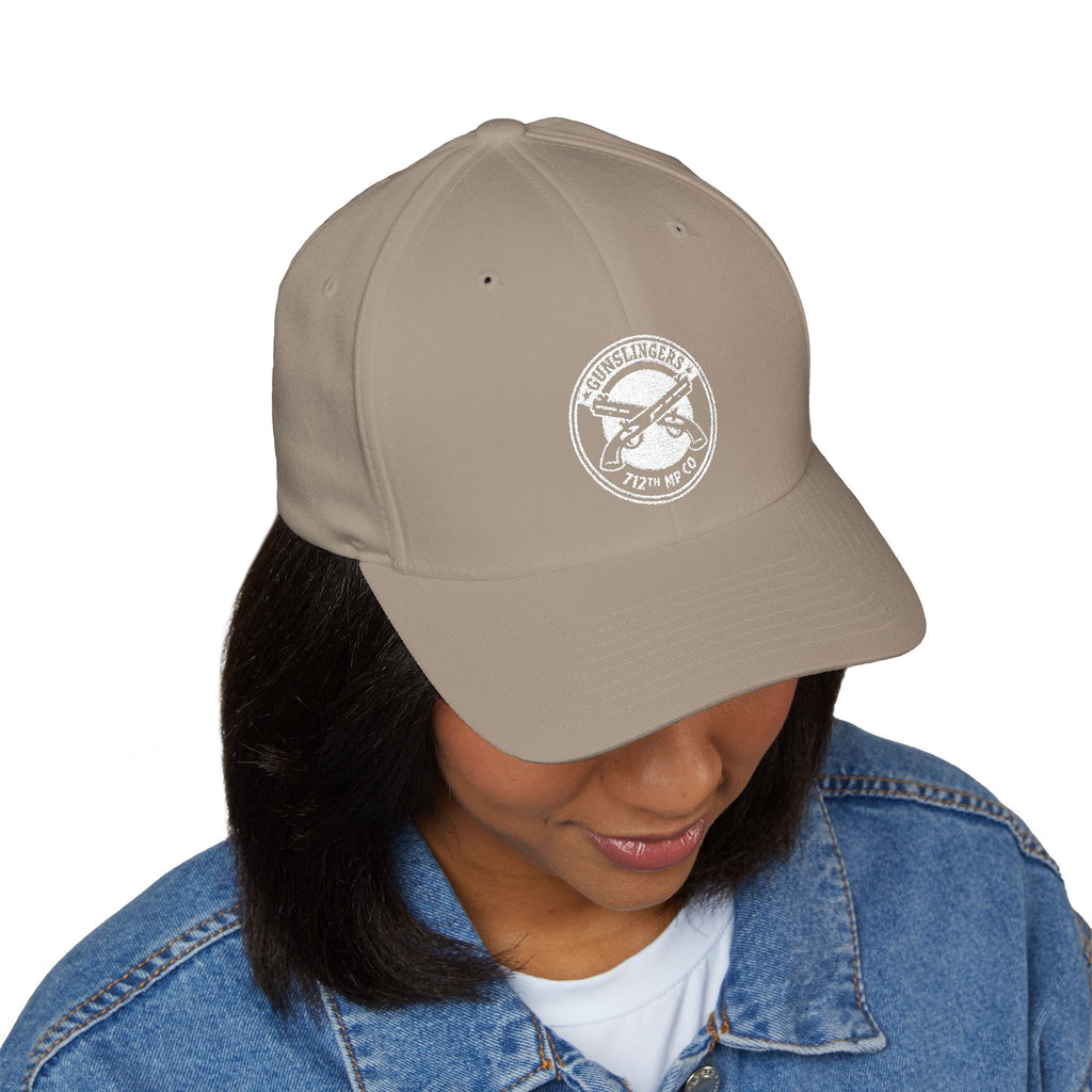 Embroidered baseball cap in khaki with white circular emblem on front panel.