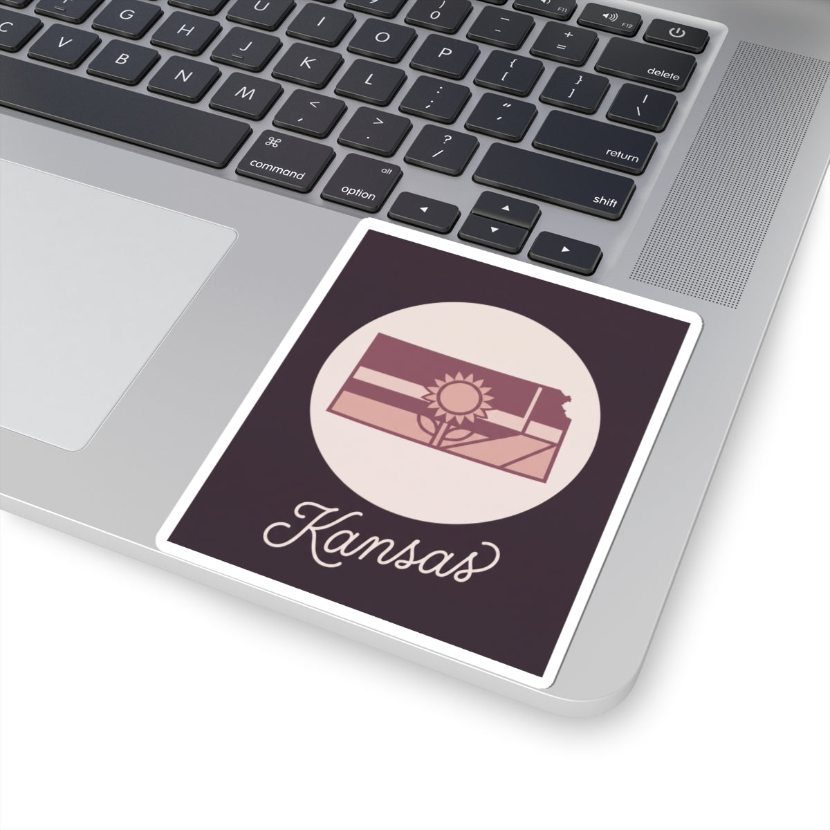 Kansas mauve vinyl decal sticker showing state silhouette, sun icon, and “Kansas” script