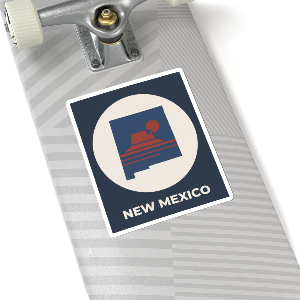 Tilted New Mexico sunset kiss-cut sticker with dark blue square, white circle, and “NEW MEXICO”.