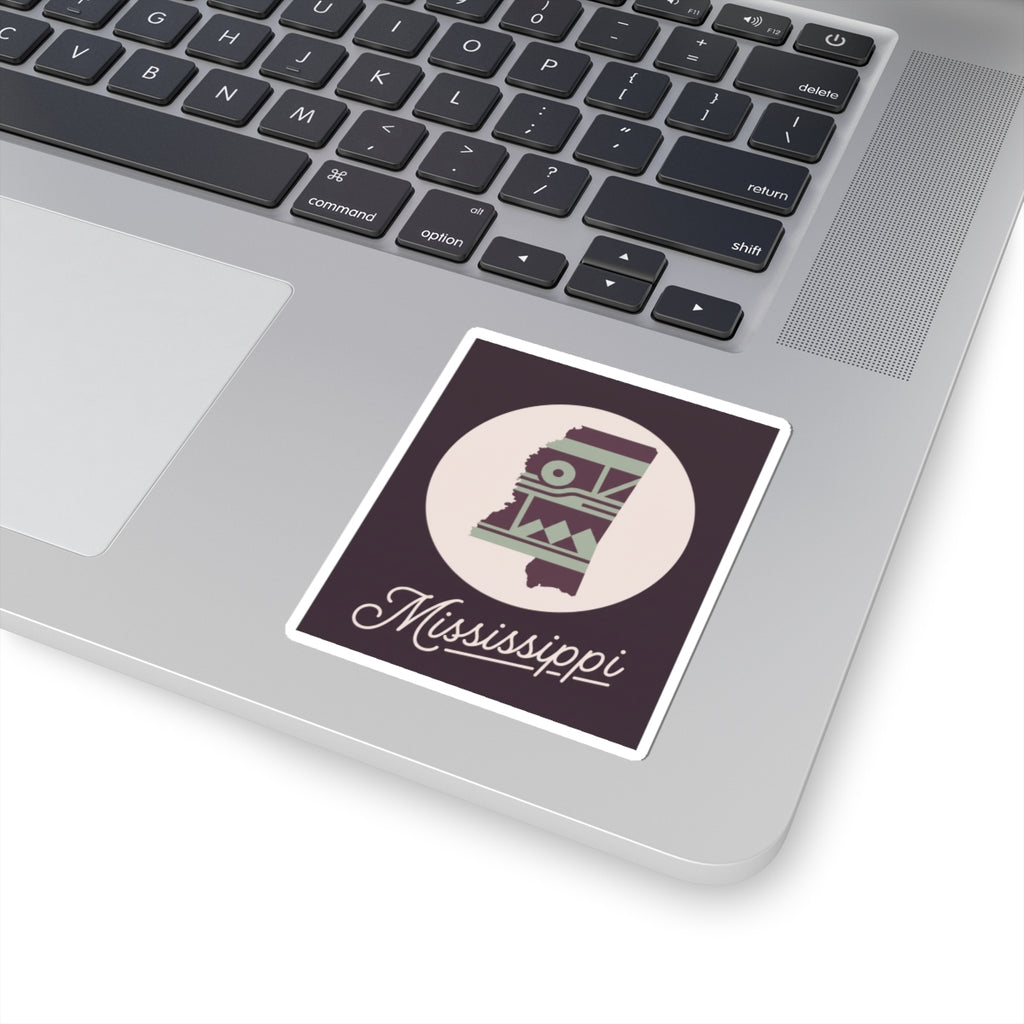 Mississippi sticker decal placed on laptop keyboard; circular emblem with cursive “Mississippi” text