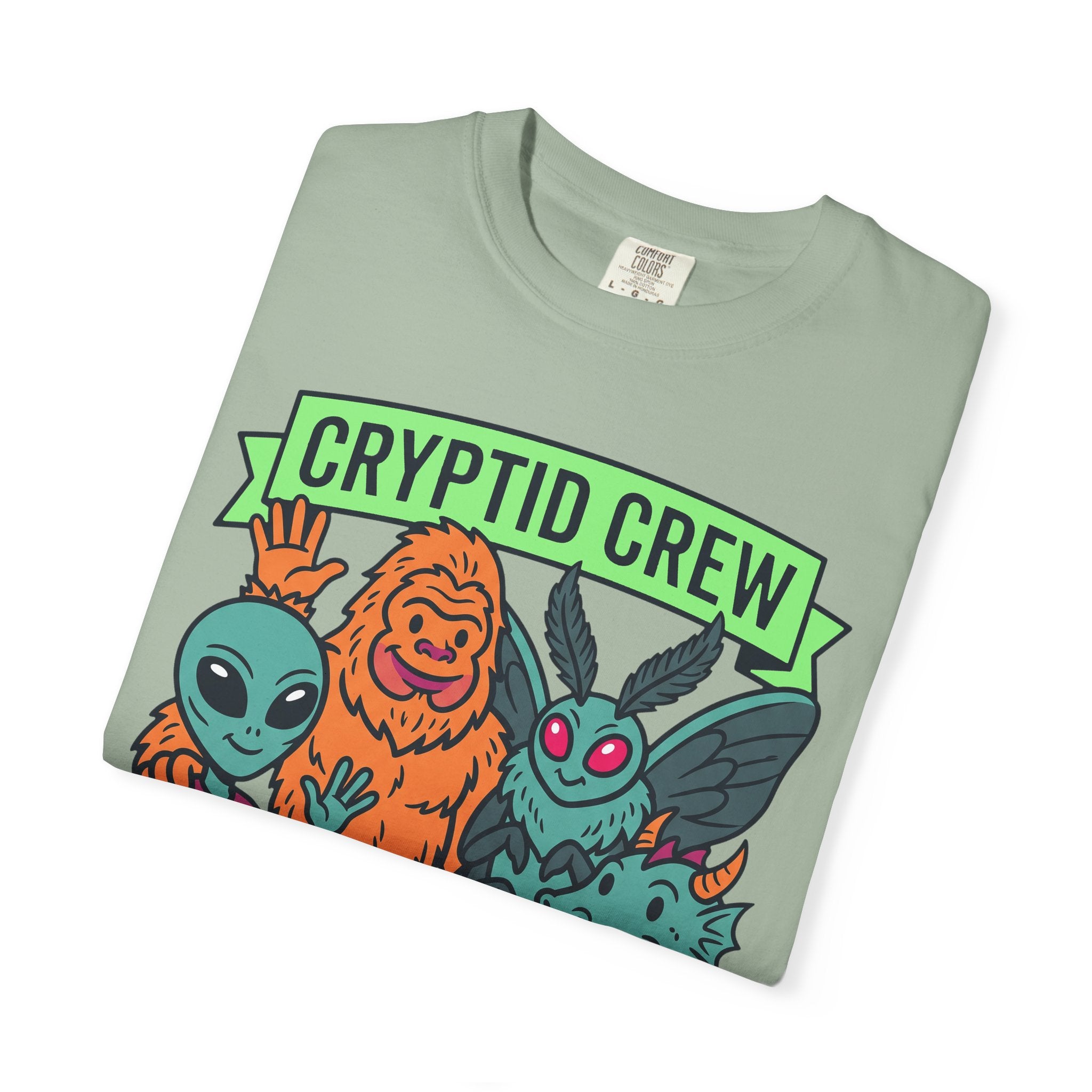 Mint green crew-neck T-shirt with 'CRYPTID CREW' graphic and alien characters.