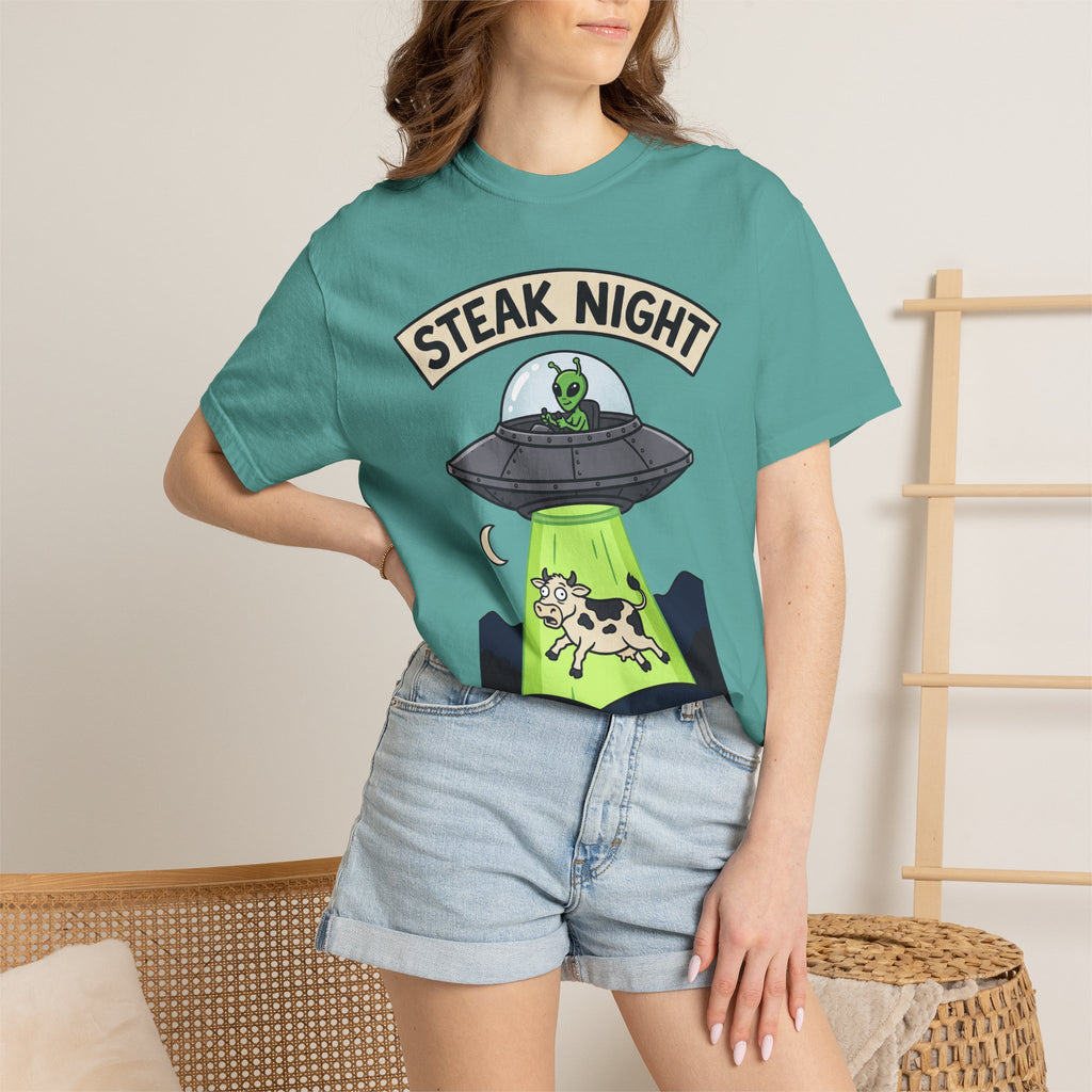 Teal graphic T-shirt on model, 'STEAK NIGHT' UFO and alien cow print.