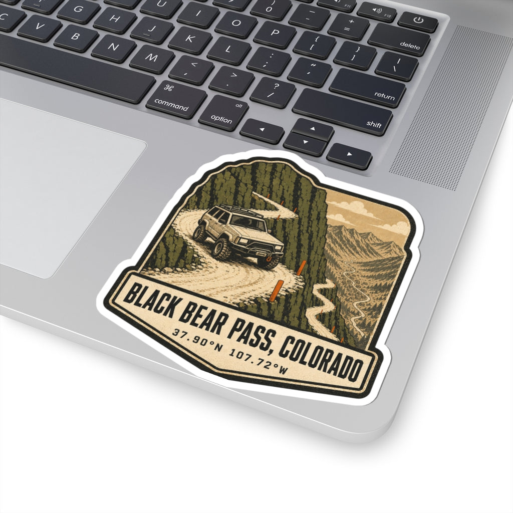 Off-road SUV sticker on laptop lid, tilted view of mountain pass and 'BLACK BEAR PASS, COLORADO'
