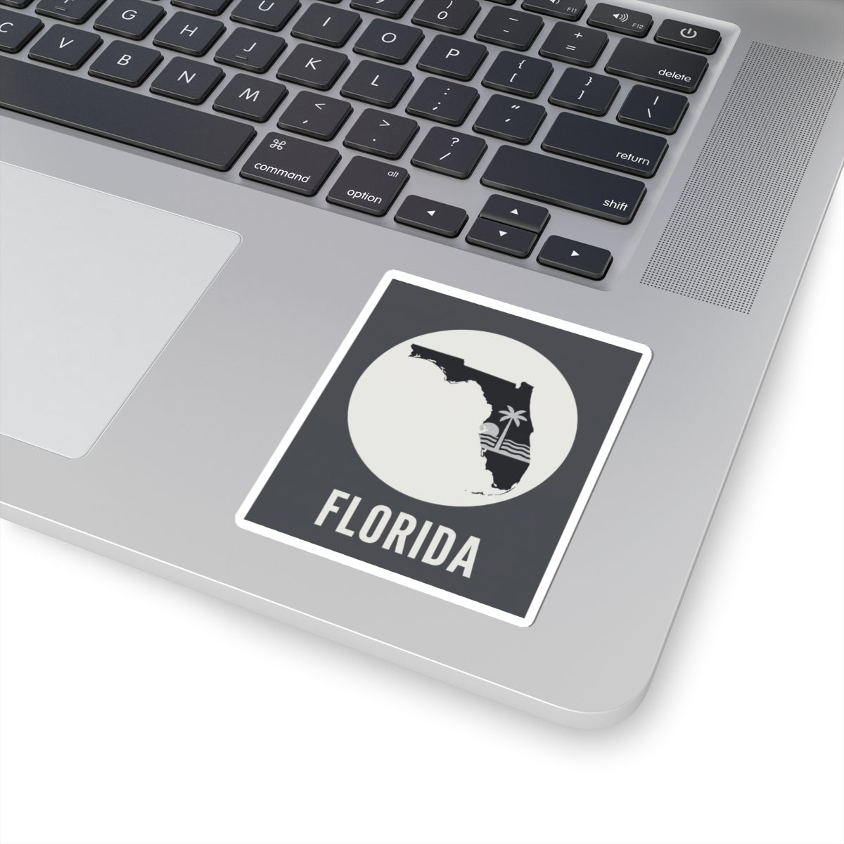 Florida silhouette kiss-cut sticker on laptop keyboard, circular palm wave and FLORIDA text