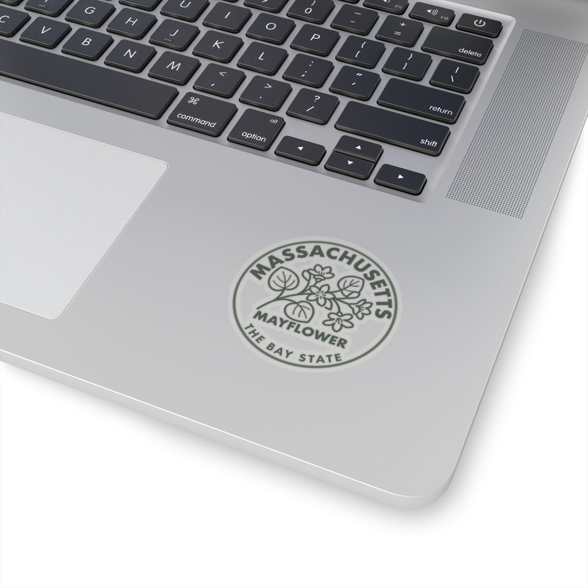 Massachusetts Mayflower state flower circular sticker on a laptop lid, gray text and botanical