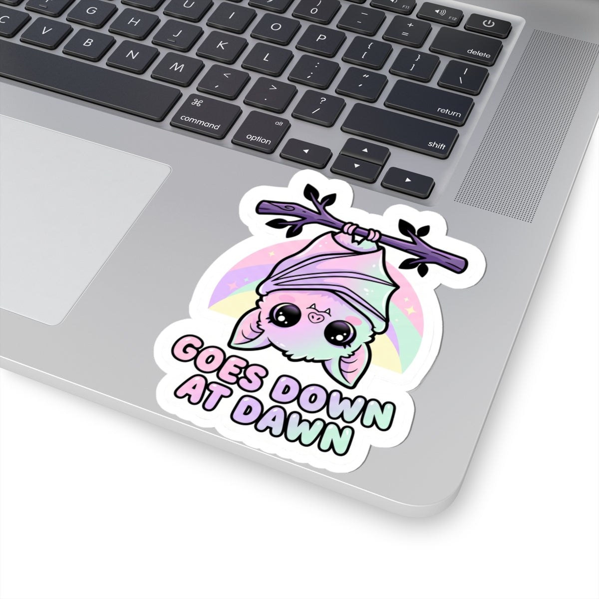 Kawaii kiss-cut vinyl sticker of purple bat character, pink hood, pastel circle, and "GOES DOWN AT DAWN"