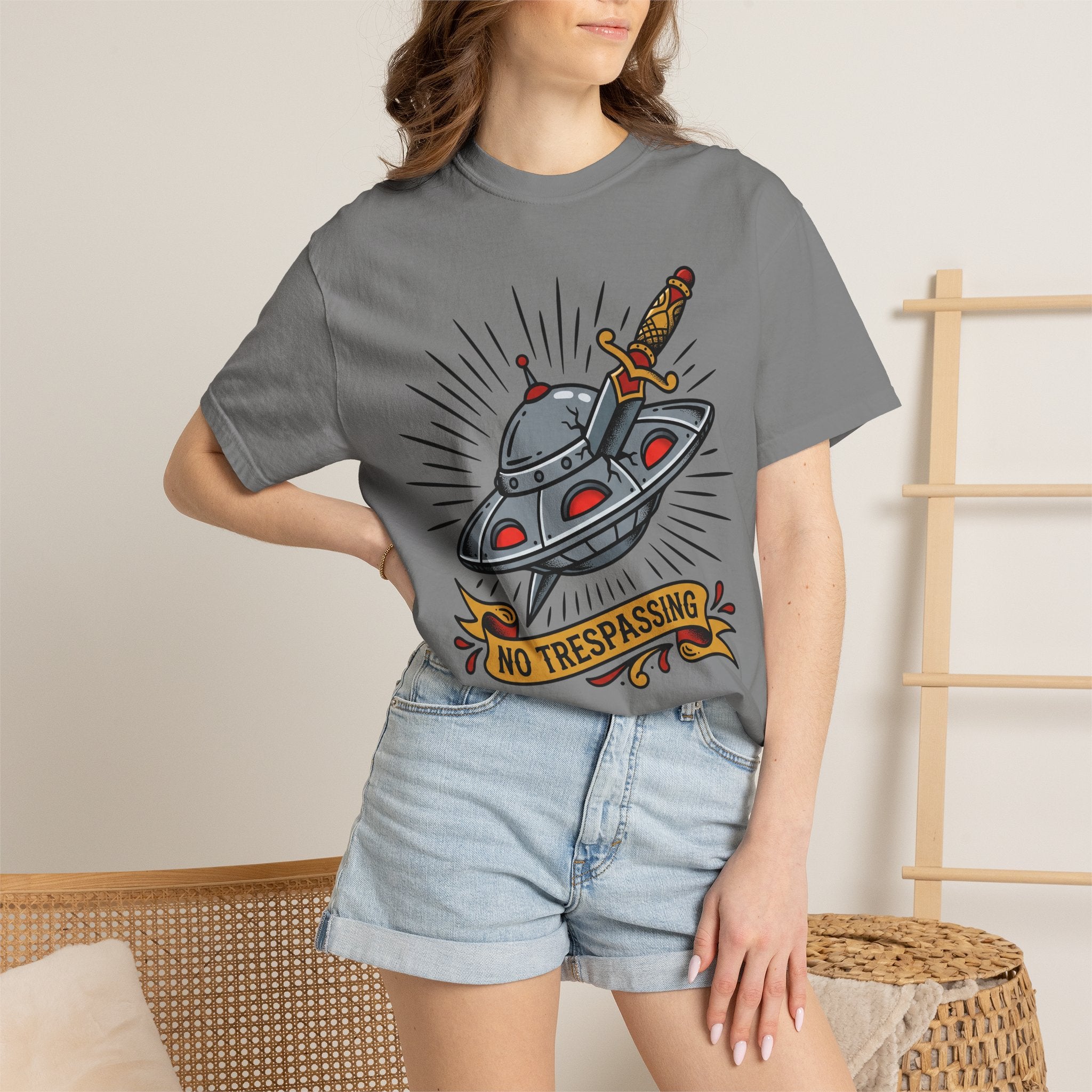 Dark gray T-shirt with cartoon UFO and dagger graphic and “No Trespassing” badge
