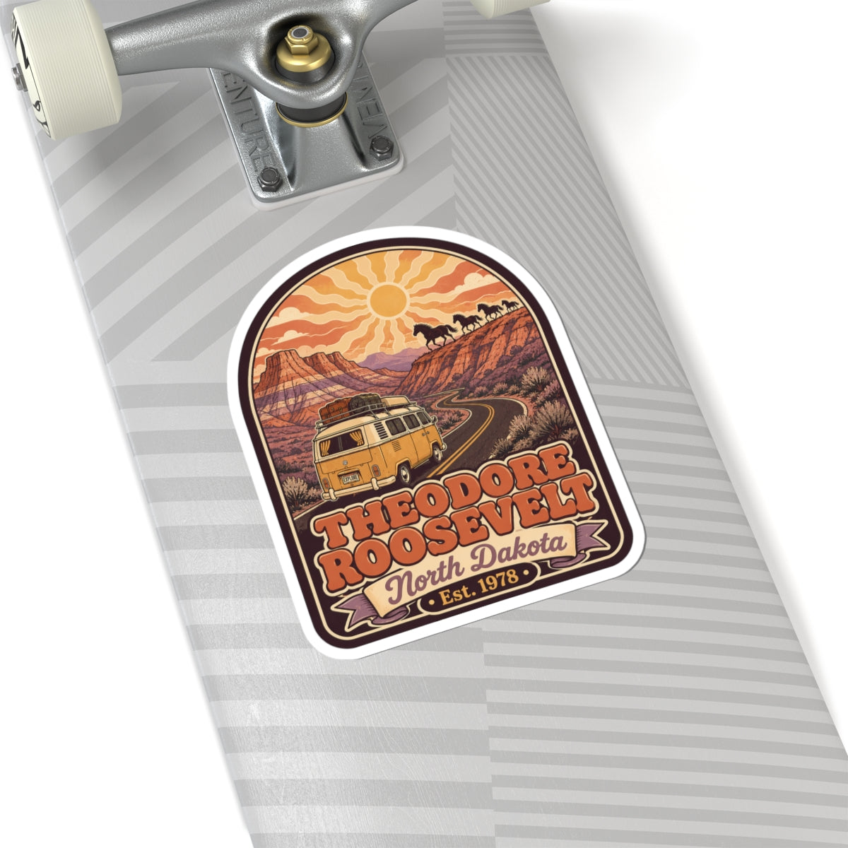 Kiss-cut sticker on a suitcase surface, camper van road scene with Theodore Roosevelt label