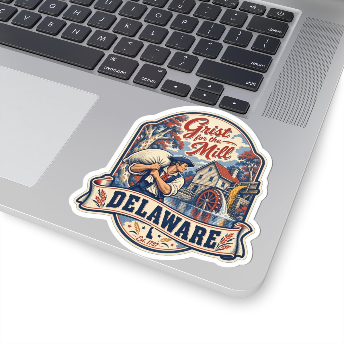 Delaware sticker on laptop: vintage mill scene with DELAWARE wordmark and red ribbon