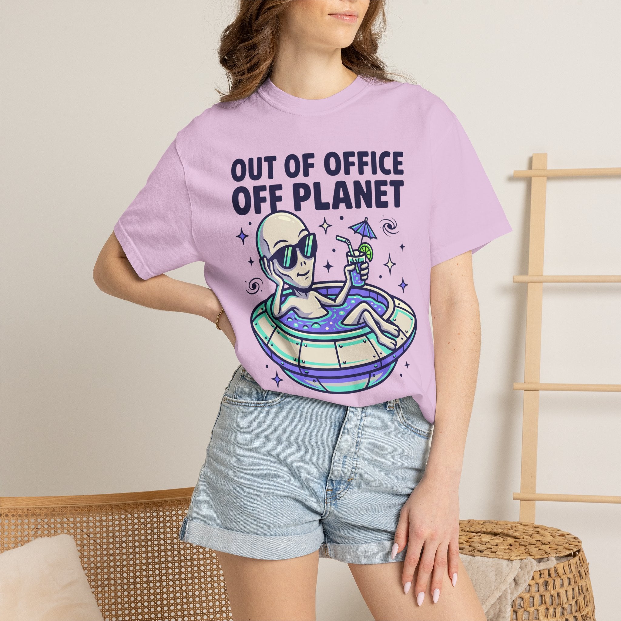 Purple T-shirt with alien on floatie and 'OUT OF OFFICE OFF PLANET' text graphic