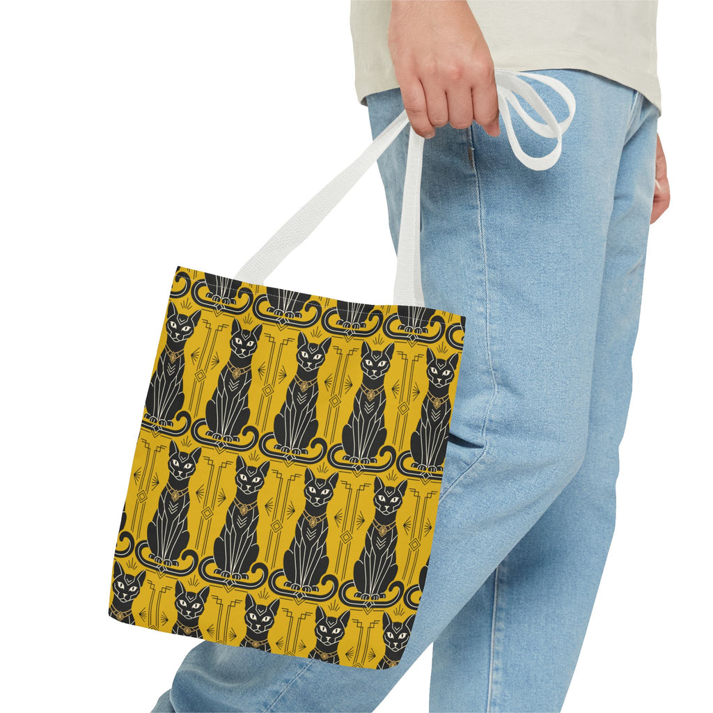 Yellow cat-pattern tote bag with black cats and navy swirls, held by white handle.