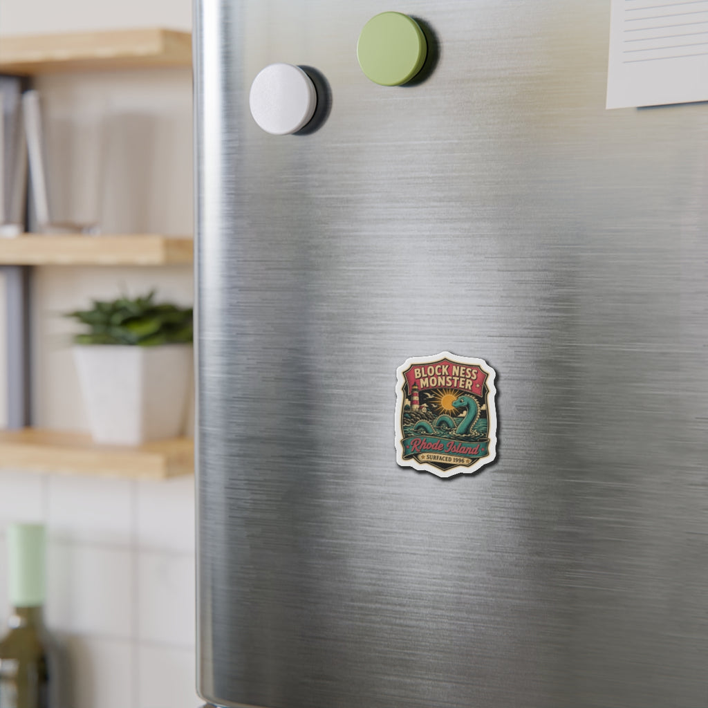 Die-cut magnet sticker on stainless fridge, teal monster design centered on the door