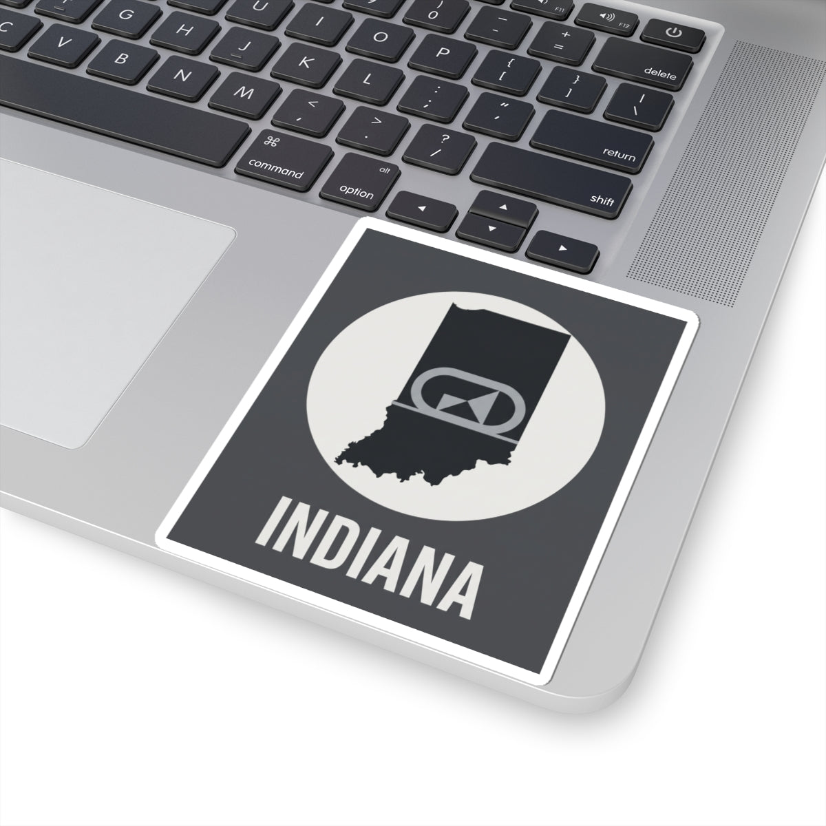 Indiana sticker on laptop trackpad area, circular badge emblem and “INDIANA” text