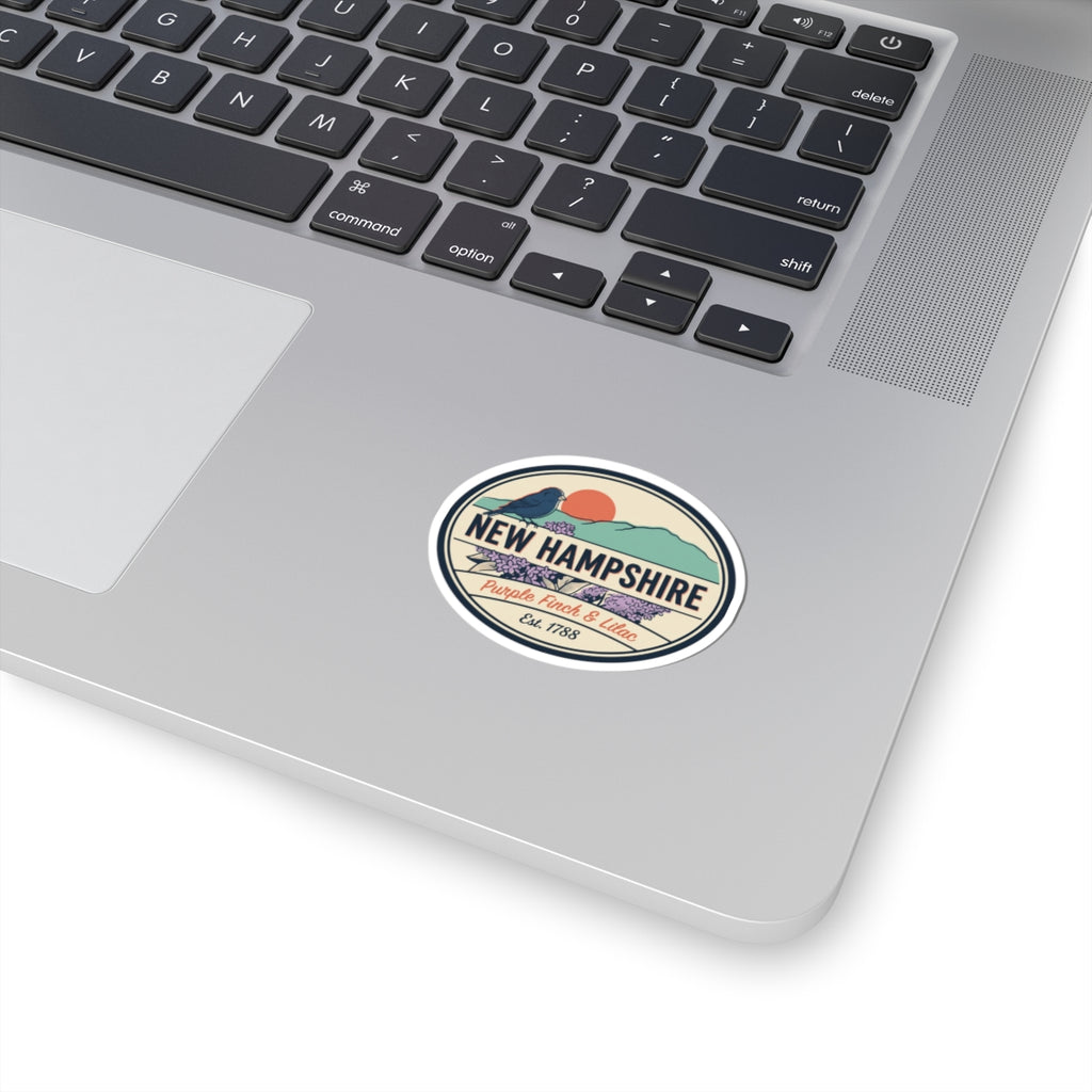 New Hampshire state badge vinyl sticker on laptop keyboard, round retro design