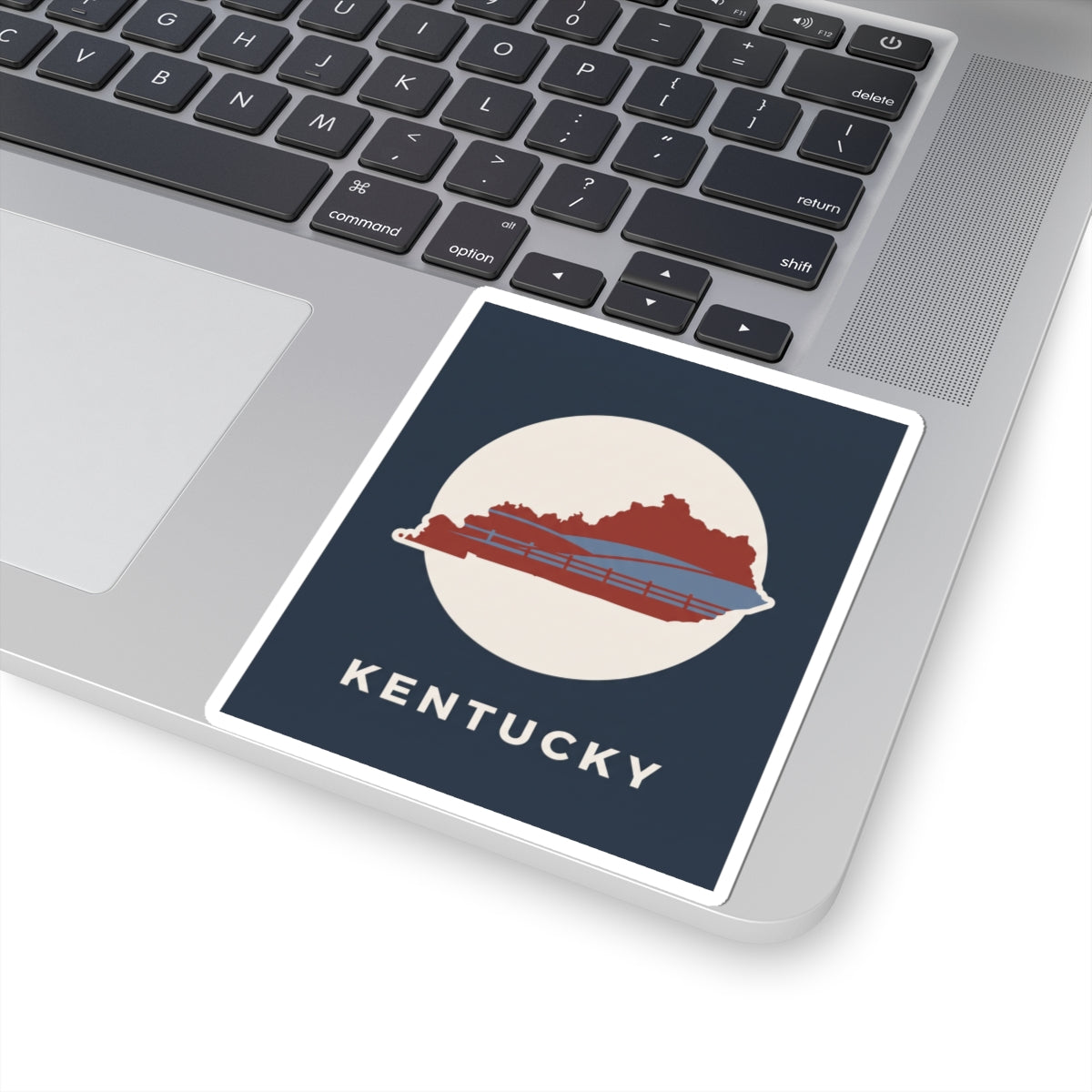 Kentucky travel decal sticker on laptop: navy square, white circle, red bridge and state, KENTUCKY