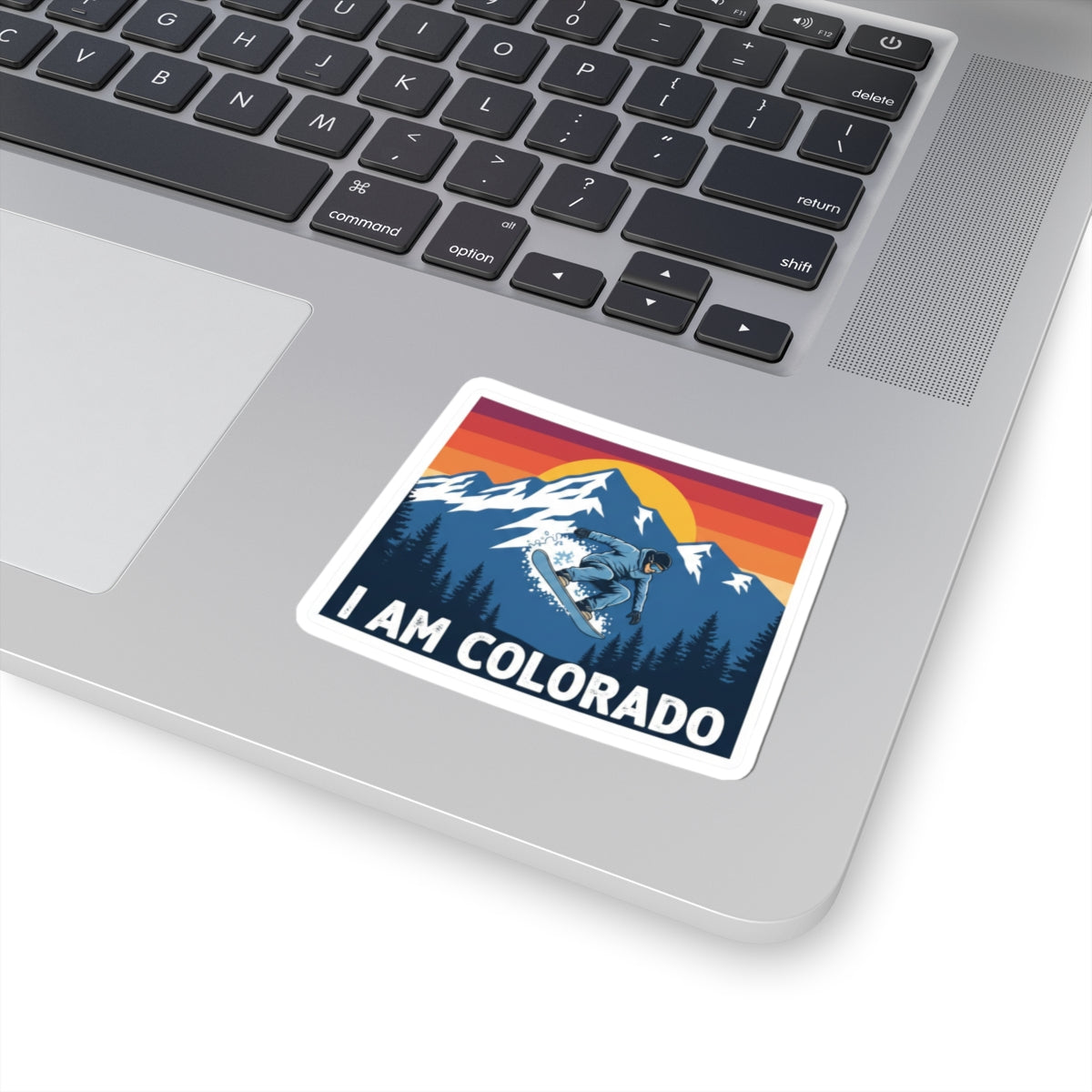 I AM COLORADO sticker on laptop surface, white border, snowboarder mountain graphic
