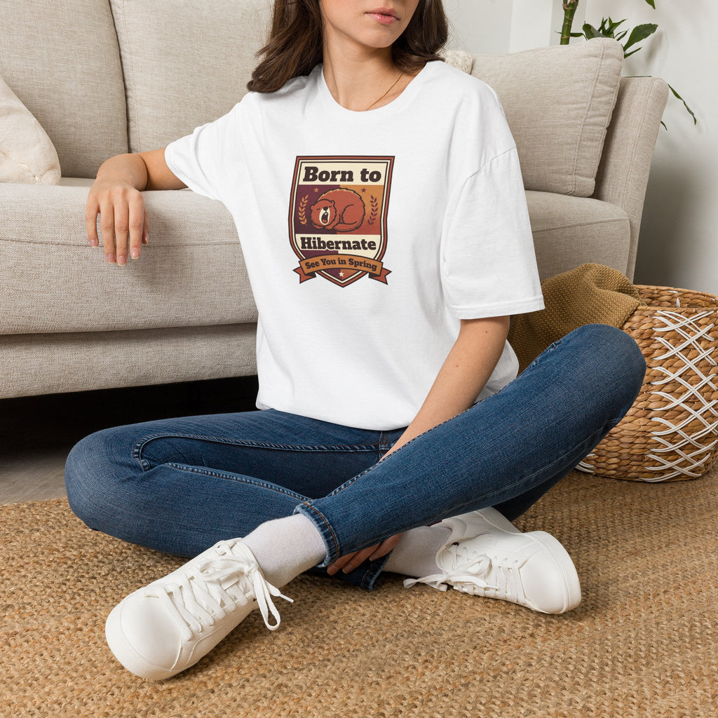 White graphic T-shirt with centered bear "Born to Hibernate" badge print, worn