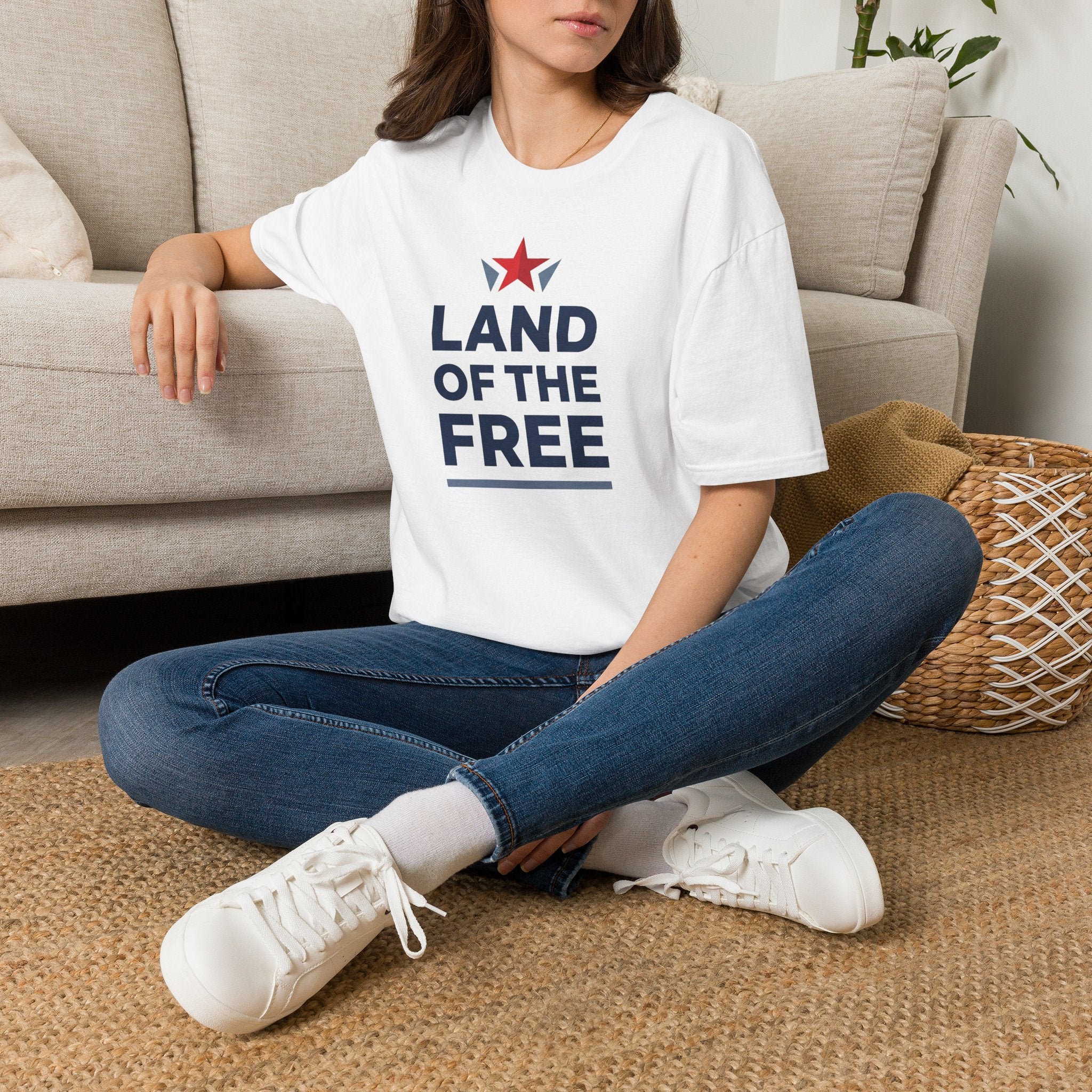 White crewneck T-shirt worn by model with red star and blue "LAND OF THE FREE" print