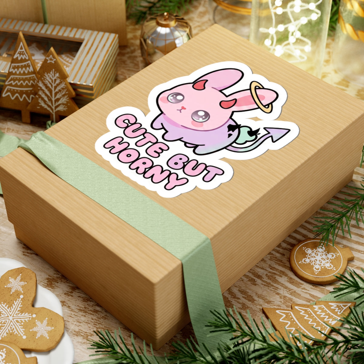 Pastel pink bunny kiss-cut sticker with halo ring and 'Cute But Horny' text on gift box