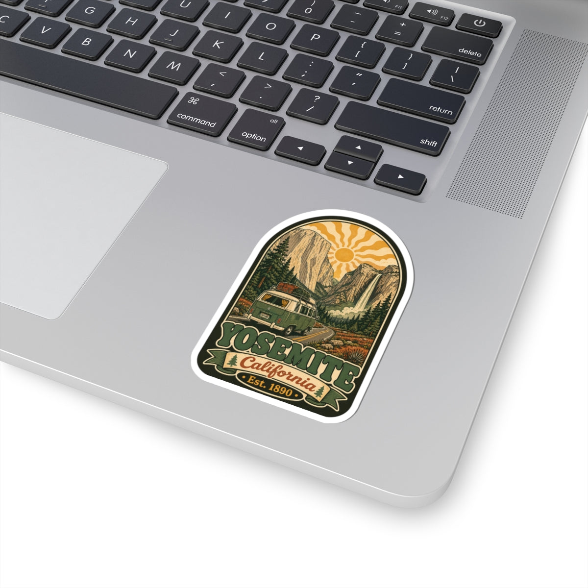 Arched camper van sticker placed on a laptop keyboard, showing “California” and “Est. 1890”