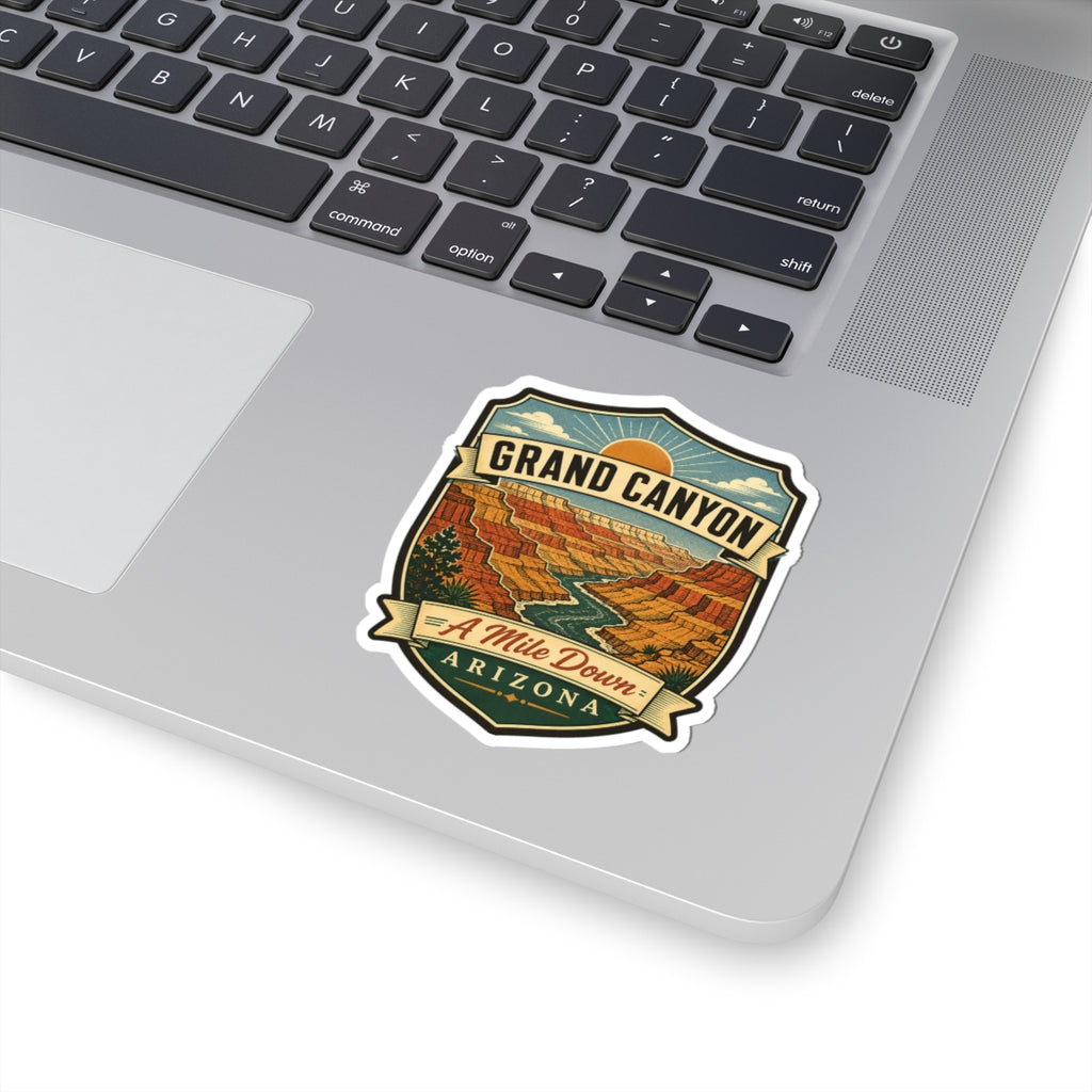 Shield-shaped travel sticker with “GRAND CANYON,” red canyon views, “A Mile Down,” “ARIZONA.”