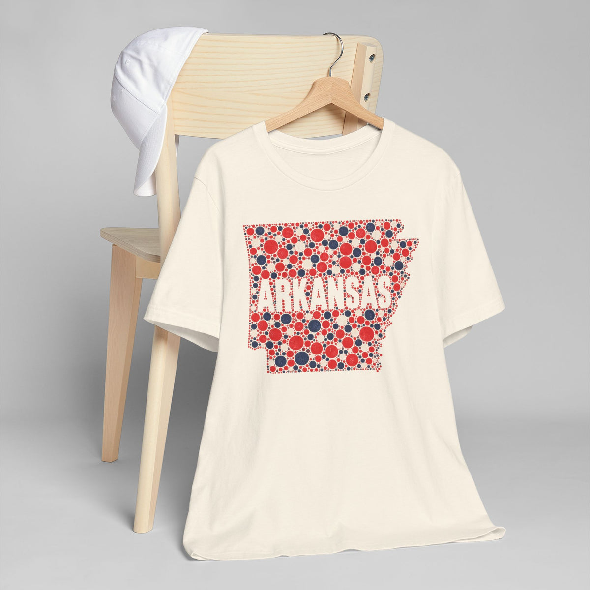 White crew-neck T-shirt with red, white, and blue Arkansas floral dot graphic.