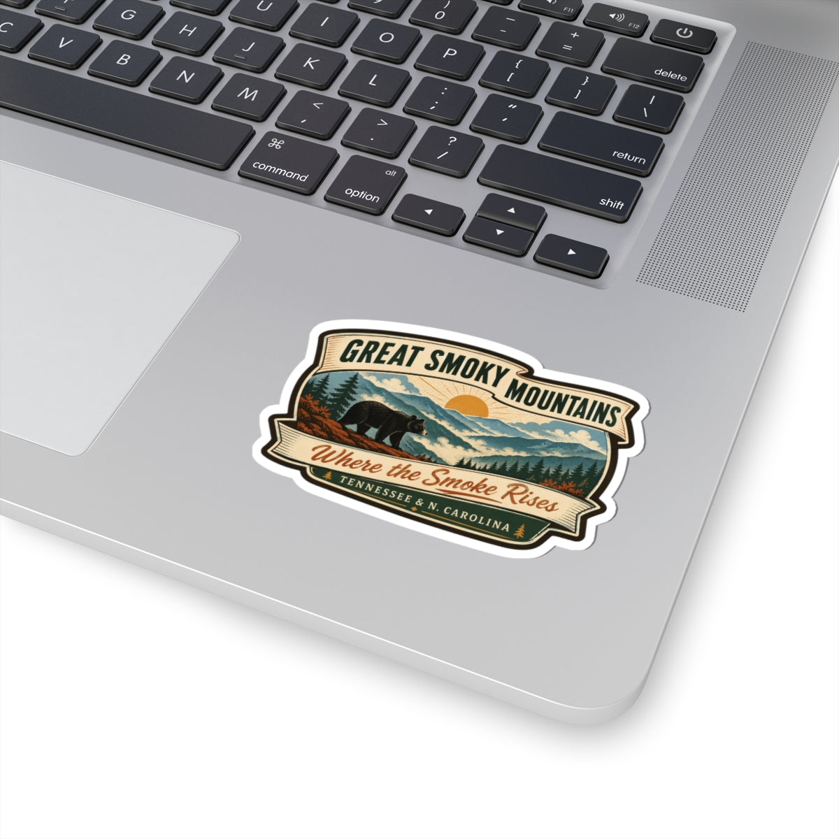 Great Smoky Mountains travel sticker on a laptop, retro bear-and-mountains badge; “Where the Smoke Rises”