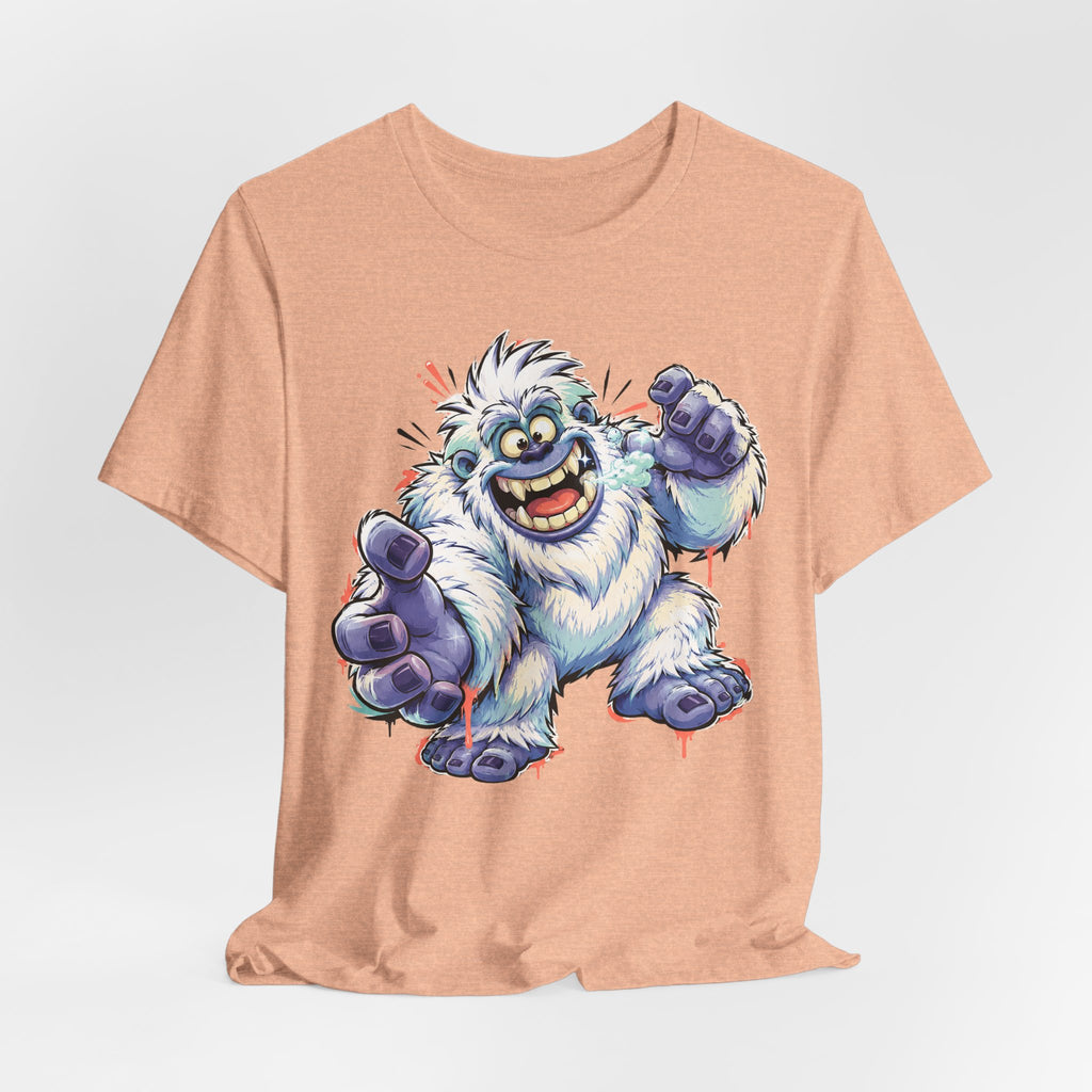 Peach T-shirt featuring a cartoon blue yeti monster holding a purple hammer.