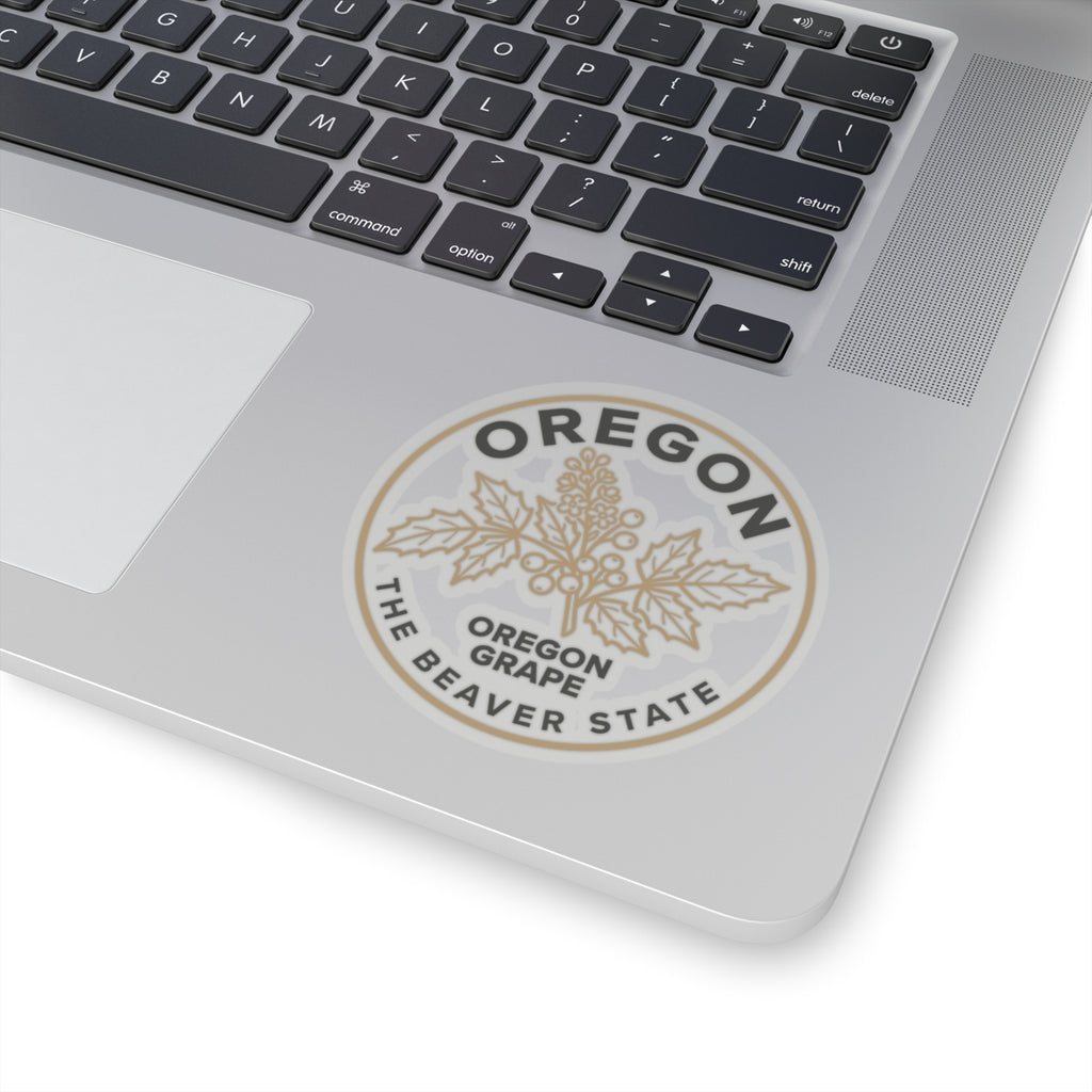 Transparent circular Oregon grape sticker on laptop lid with 'OREGON' and 'THE BEAVER STATE' text