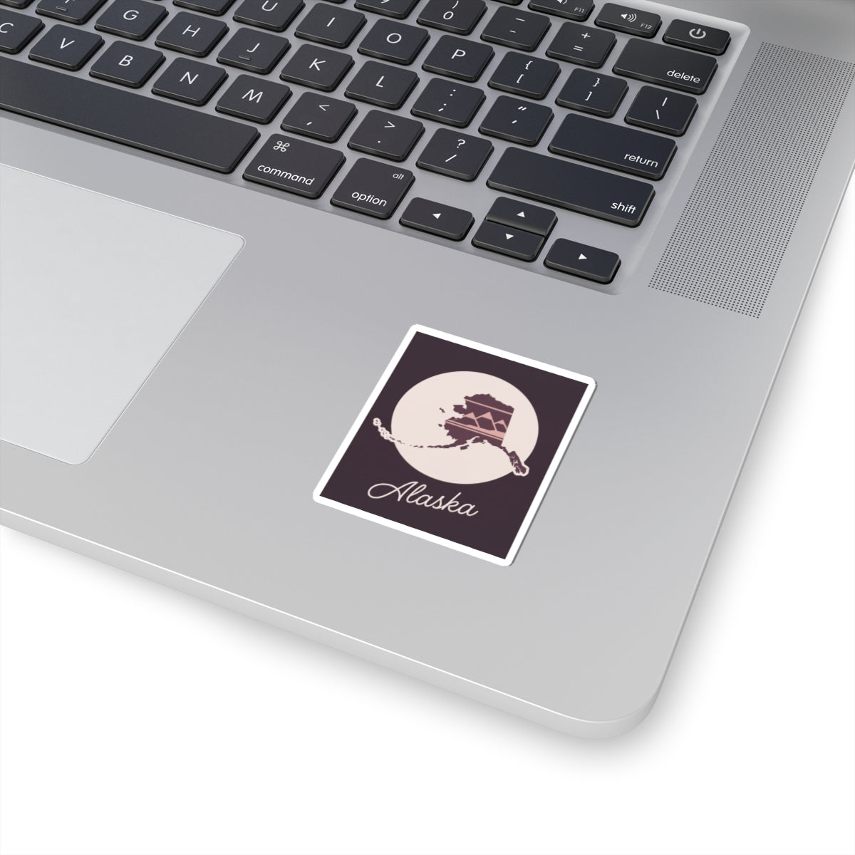 Square mauve Alaska state silhouette vinyl sticker with dark purple border and cursive text