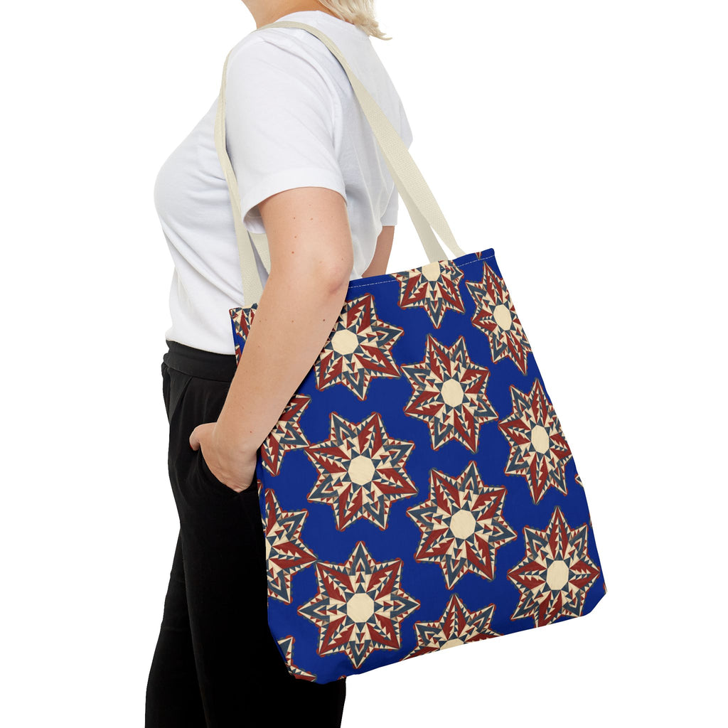 Navy tote bag with red and cream starburst floral pattern, long shoulder handles.