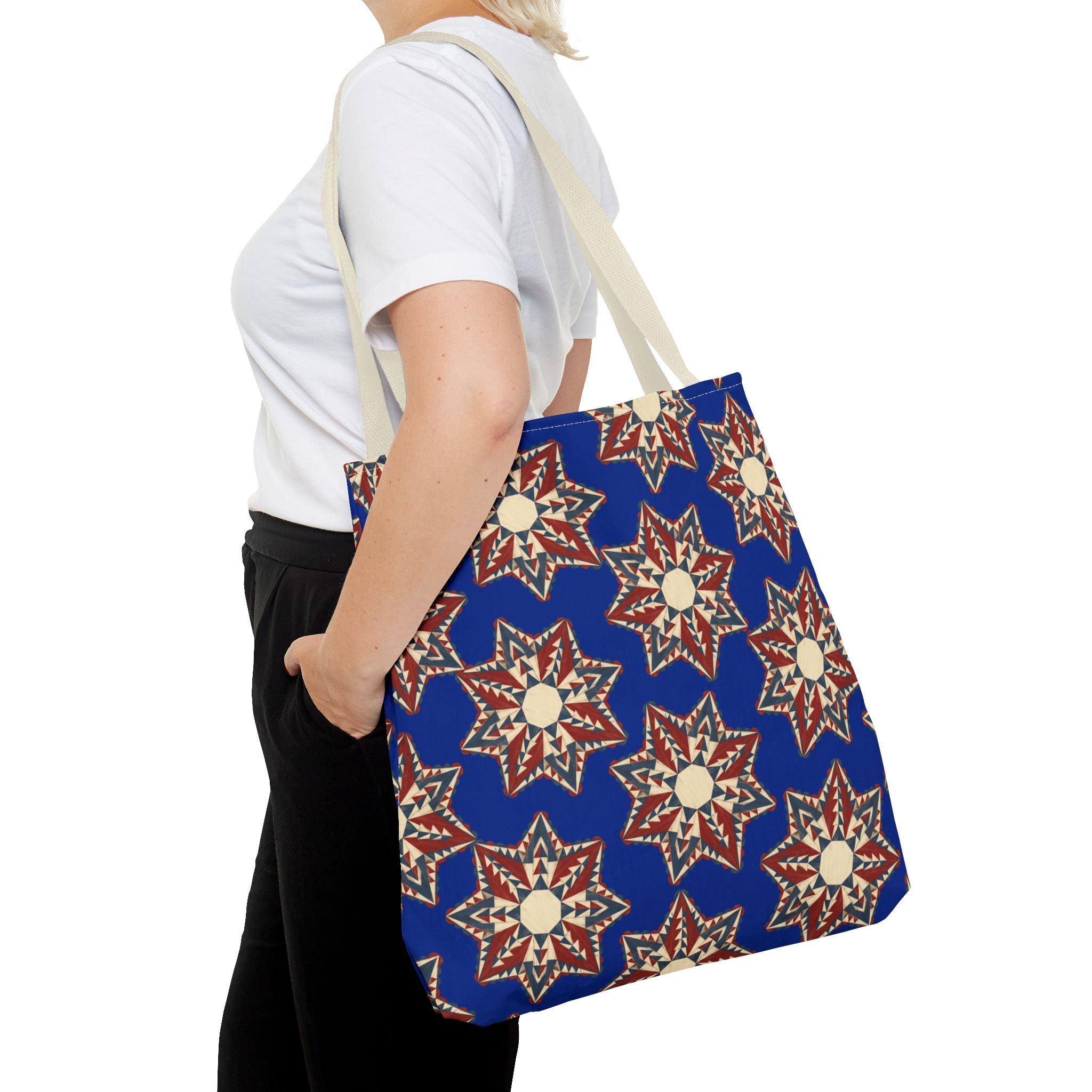 Navy tote bag with red and cream starburst floral pattern, long shoulder handles.