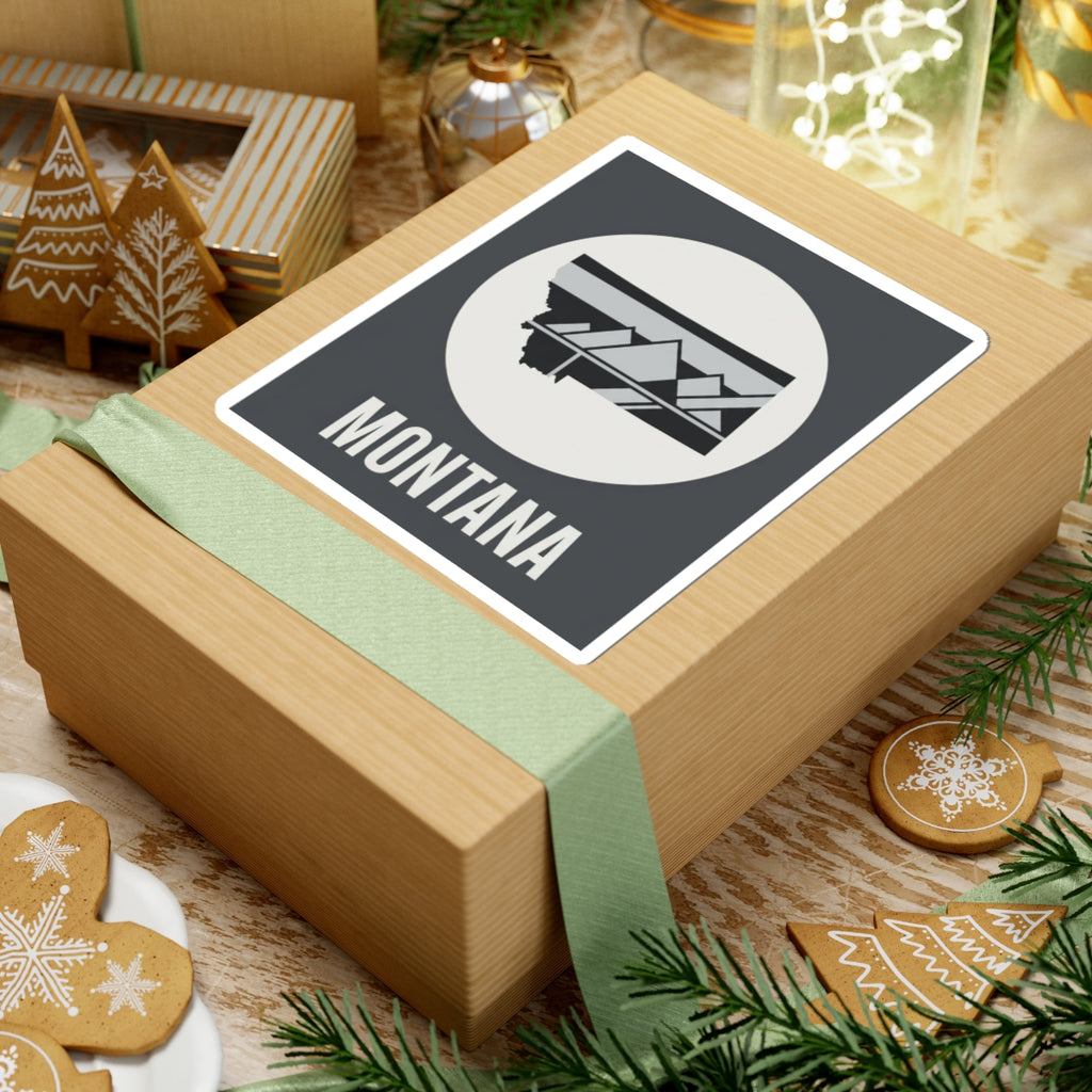 Montana mountain badge sticker on wrapped gift, white circle landscape emblem and MONTANA lettering