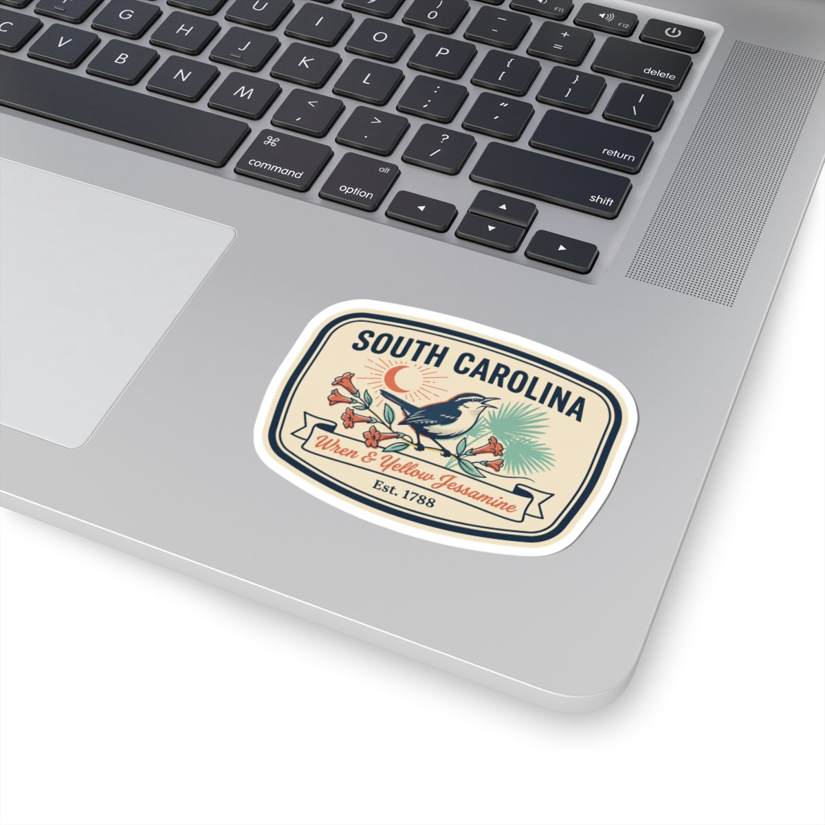 South Carolina sticker on a laptop keyboard: wren and yellow jessamine crest, Est. 1788