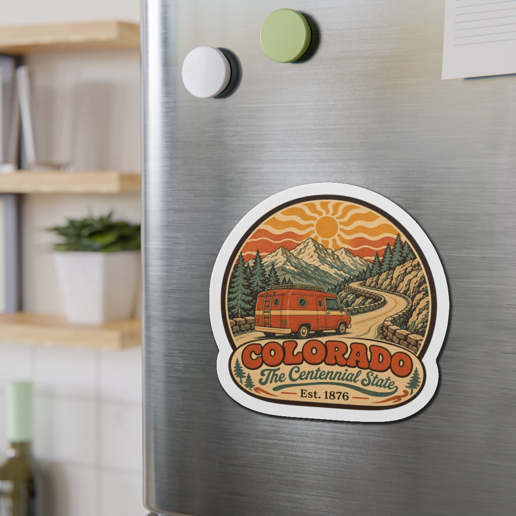 Die-cut Colorado Centennial State magnet featuring retro van, mountains, and orange sky