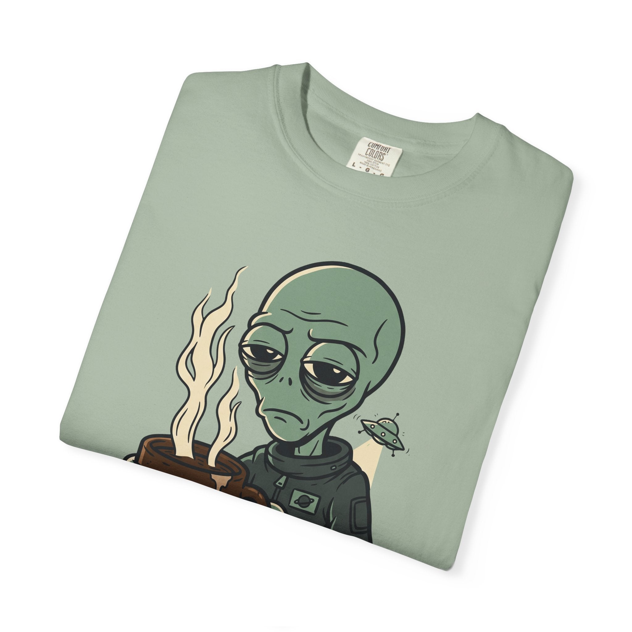 Sage green crew-neck T-shirt with alien holding coffee and small spaceship graphic.
