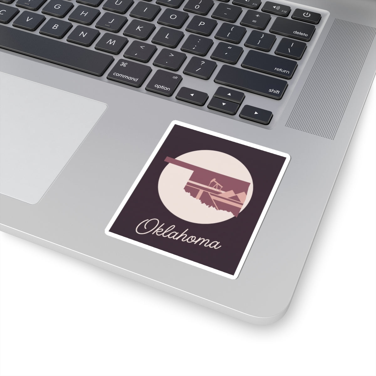 Oklahoma state sticker decal on laptop: maroon square with oil derrick silhouette and script