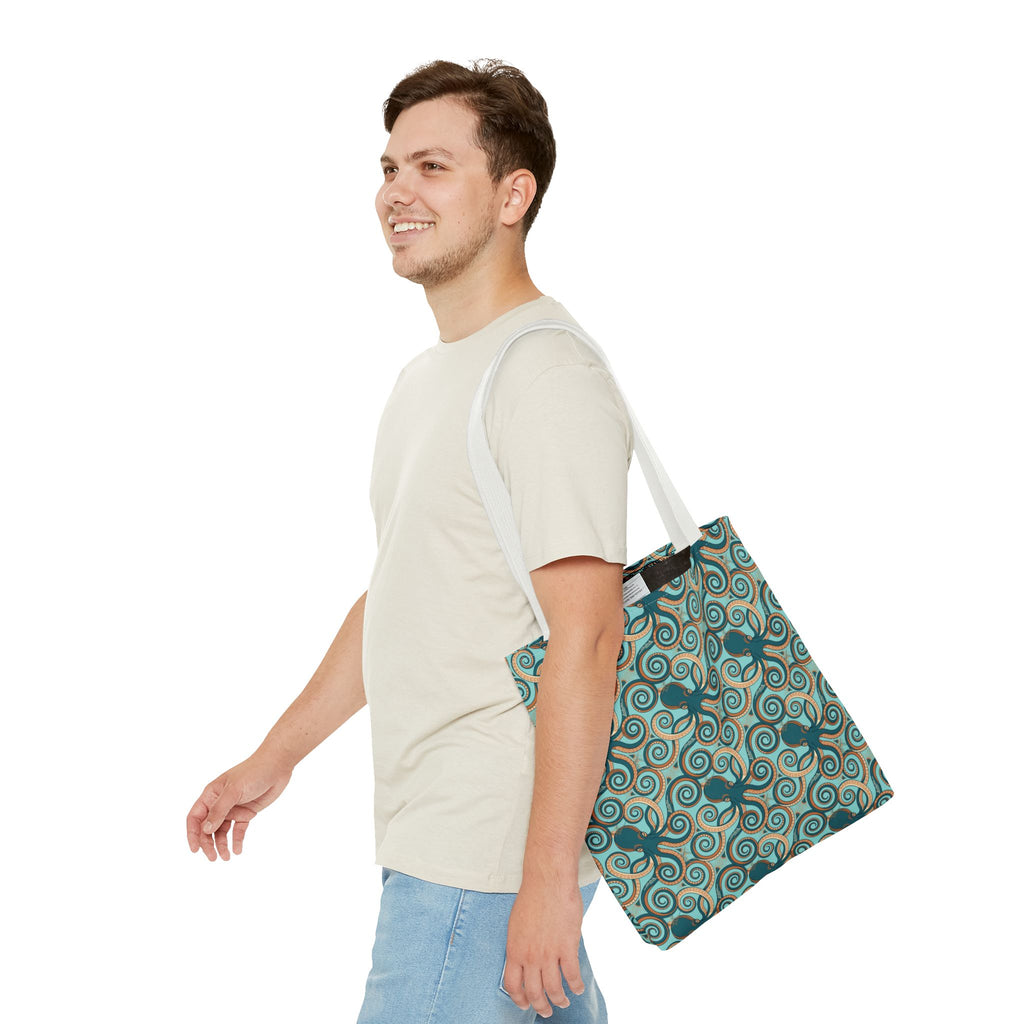 Octopus swirl tote bag worn on shoulder; teal all-over pattern with white handles.