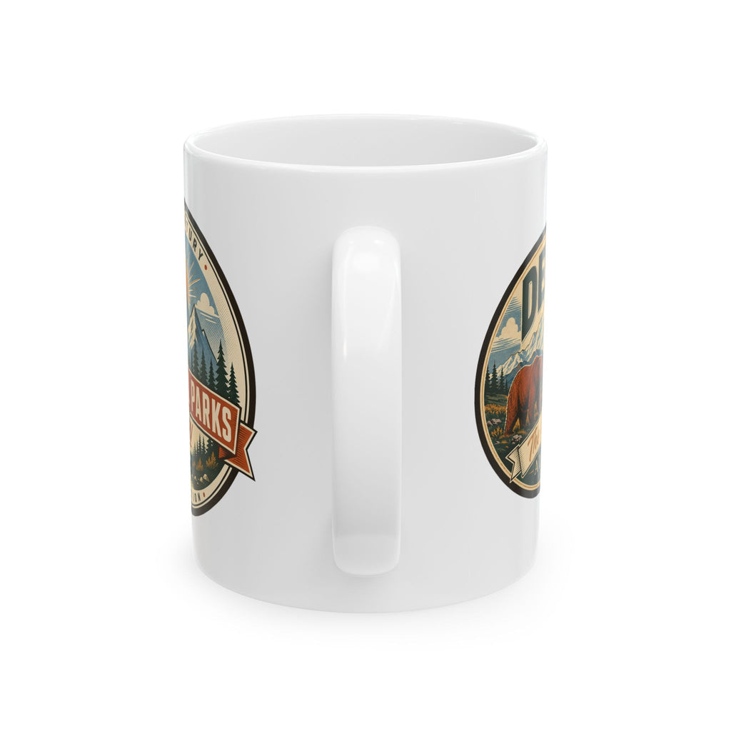 White ceramic mug with vertical handle cutout and two side badge graphics