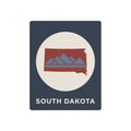 South Dakota metal art sign with circular emblem, red mountains on dark blue background