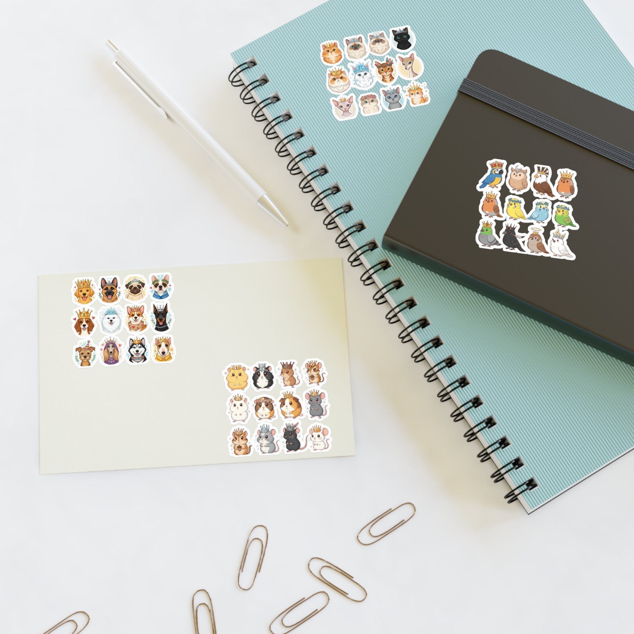 Royal Pets die-cut stickers on paper, beside notebook