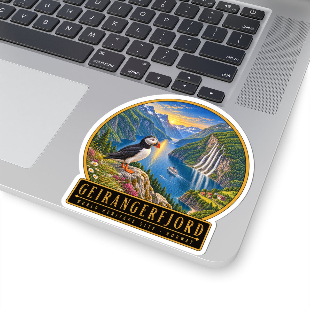 Geirangerfjord sticker on laptop: puffin and fjord waterfall scene with “WORLD HERITAGE” text