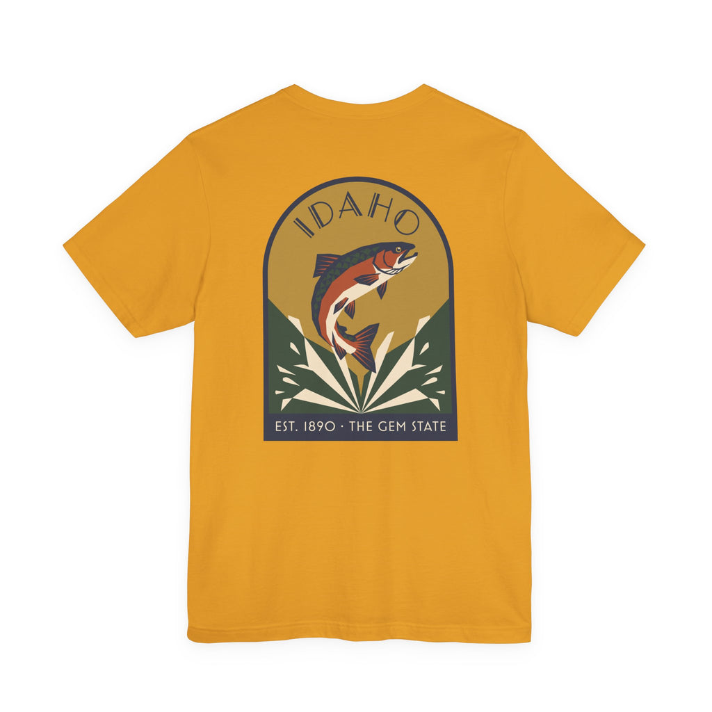 Mustard/gold crewneck t-shirt with circular Idaho trout badge graphic and "EST. 1890 • THE GEM STATE" text.