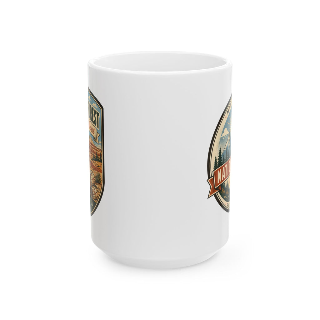 White ceramic mug with side graphic badge in a shield frame, desert and trees