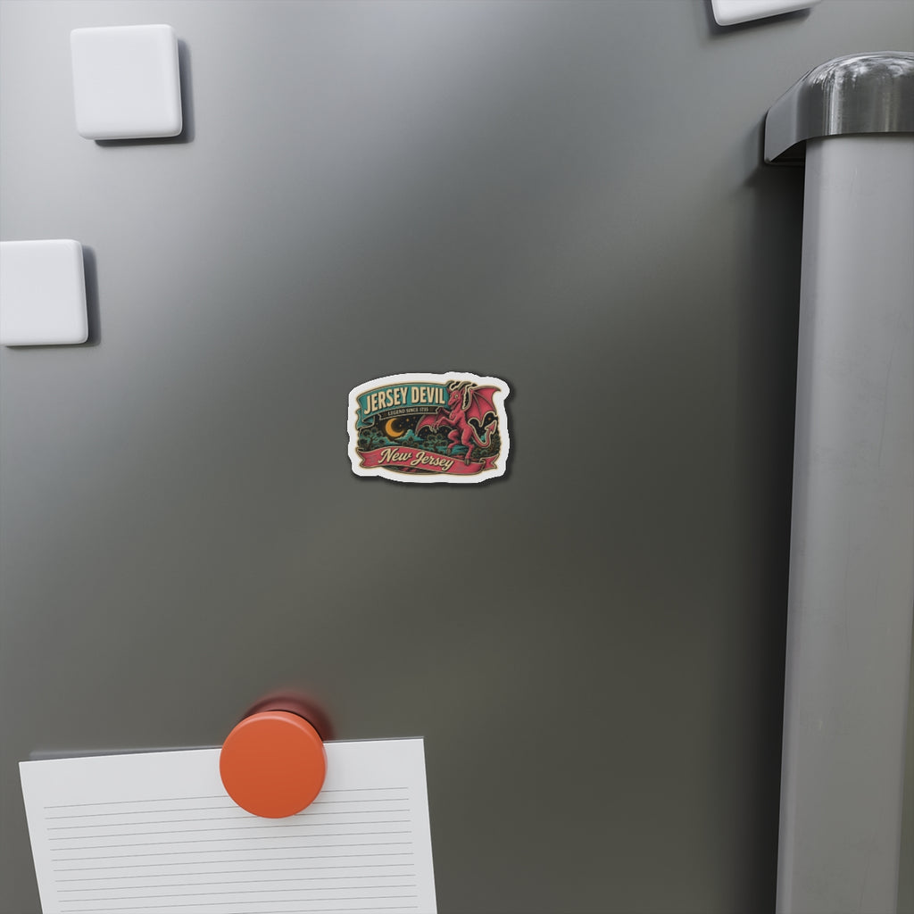 Die-cut Jersey Devil magnet on a stainless-steel refrigerator door, small emblem artwork.