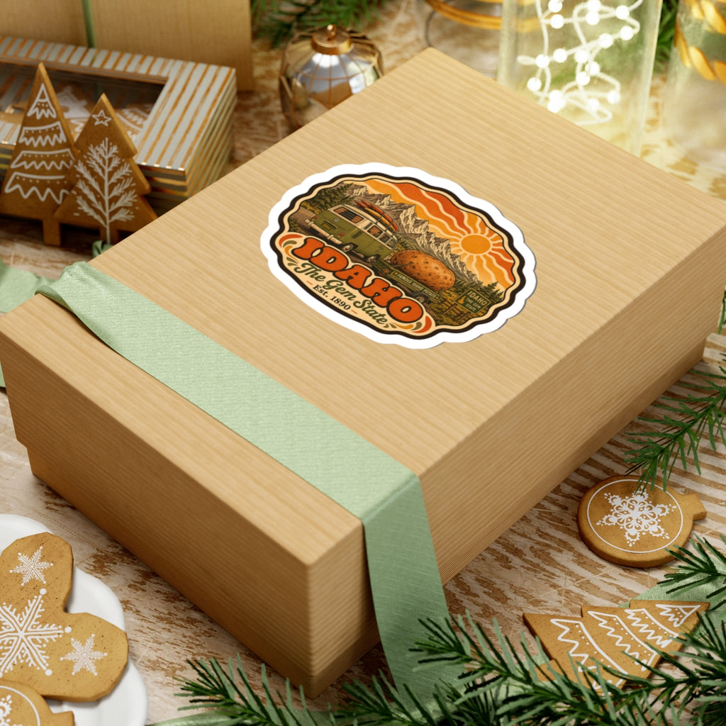 Idaho vintage roadtrip sticker on wooden gift box, showing green van, potato, mountains and sun.