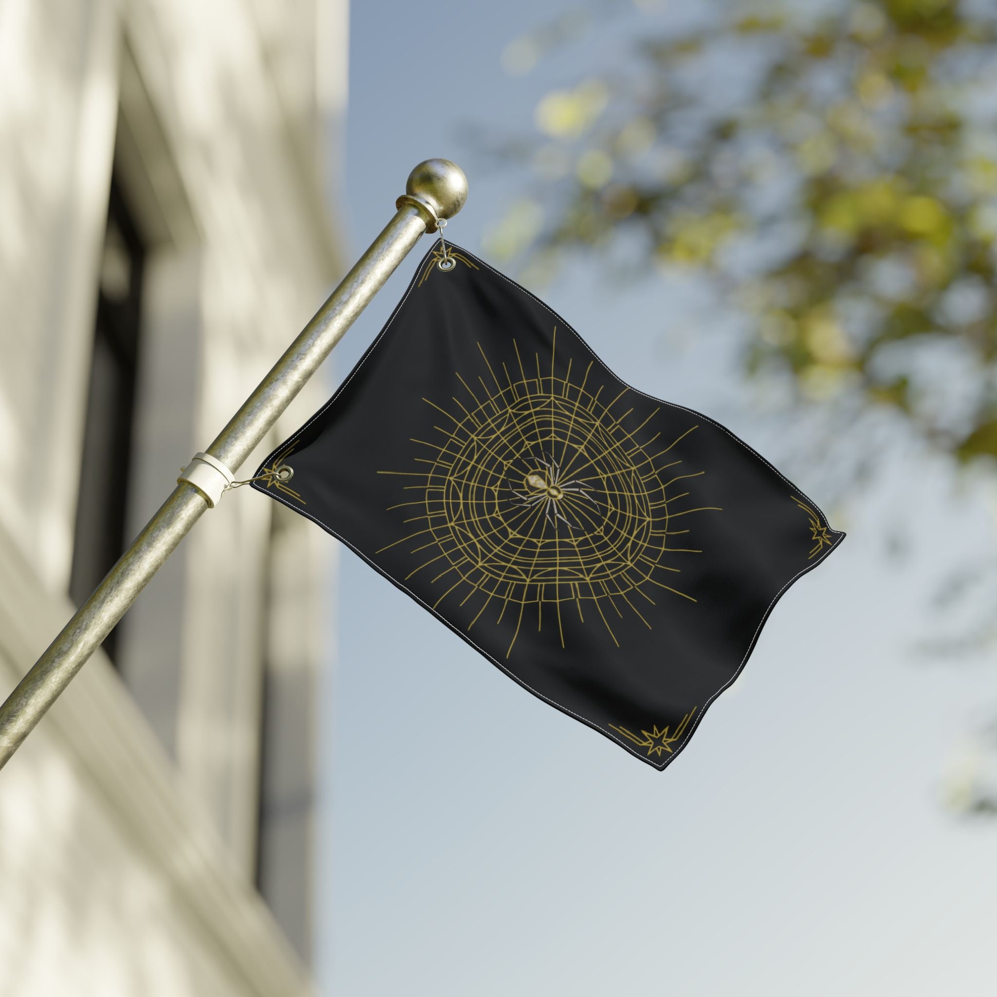 Black Halloween banner with gold spider web mandala, hanging from a metal fence pole