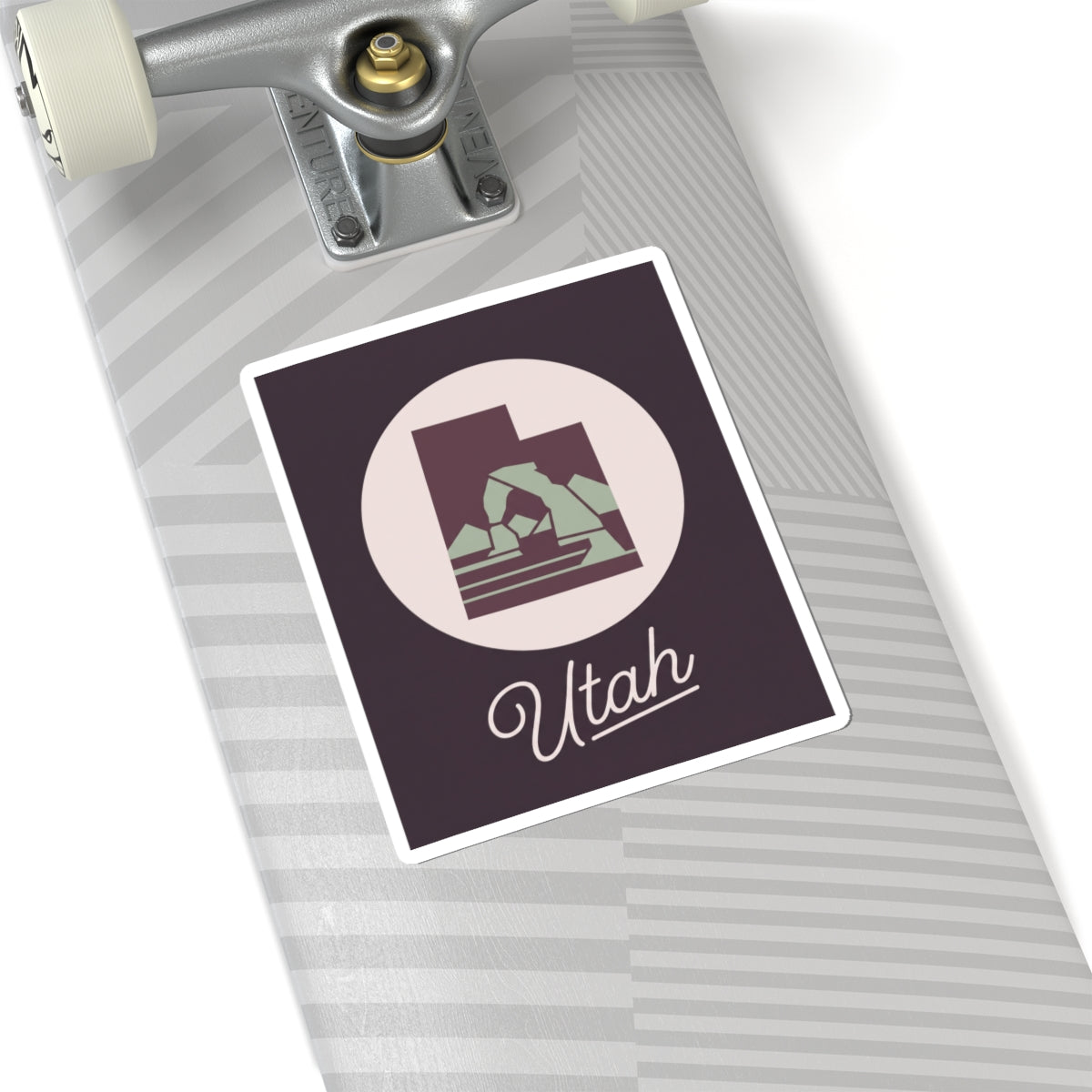 Utah state decal sticker on a luggage handle, dark purple square with circle mountain and “Utah”.