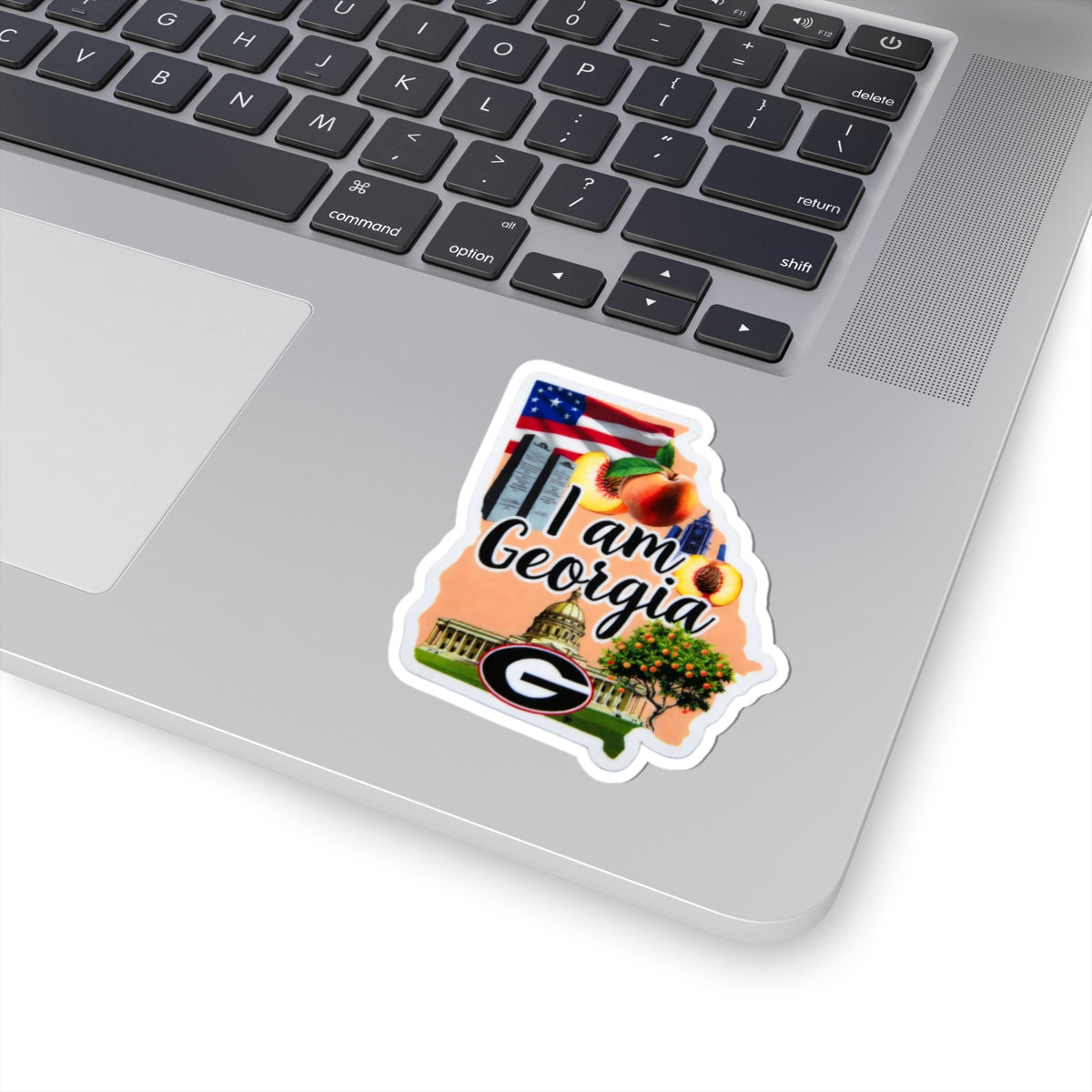 I am Georgia sticker on laptop keyboard, white border, Georgia lettering and logo
